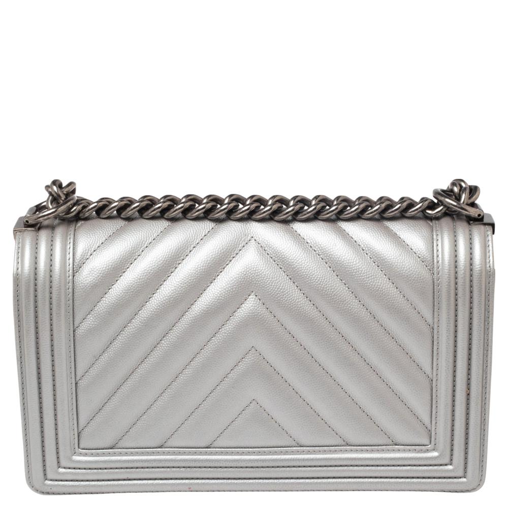 The Boy flap bag is an icon of Chanel's. This here is a version in metallic grey chevron leather. It brings the signature label within the fabric interior and the iconic CC push lock on the flap. The piece has gunmetal-tone hardware and a shoulder