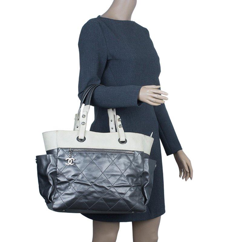 This roomy tote bag is part of Chanel’s 2011 Paris Biarritz collection. It is made from quilted black leather with a matching canvas bottom. It features an extended canvas upper, zipper pocket with CC medallion zipper pull, side pockets and double