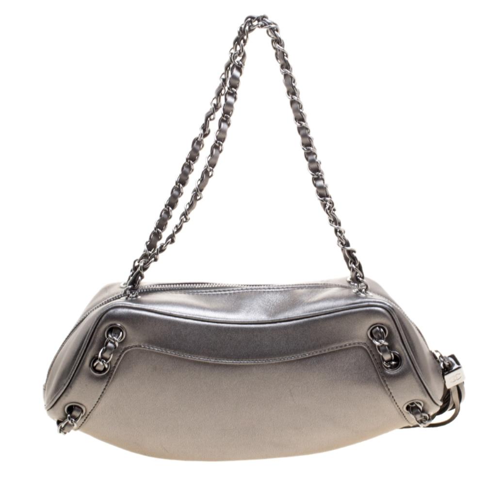 Get evening-ready with this exquisite creation from the house of Chanel. Featuring a unique structure, this bag is designed in a metallic grey leather body and detailed with a playful tassel on the side. Ideally proportioned to stow just essentials,