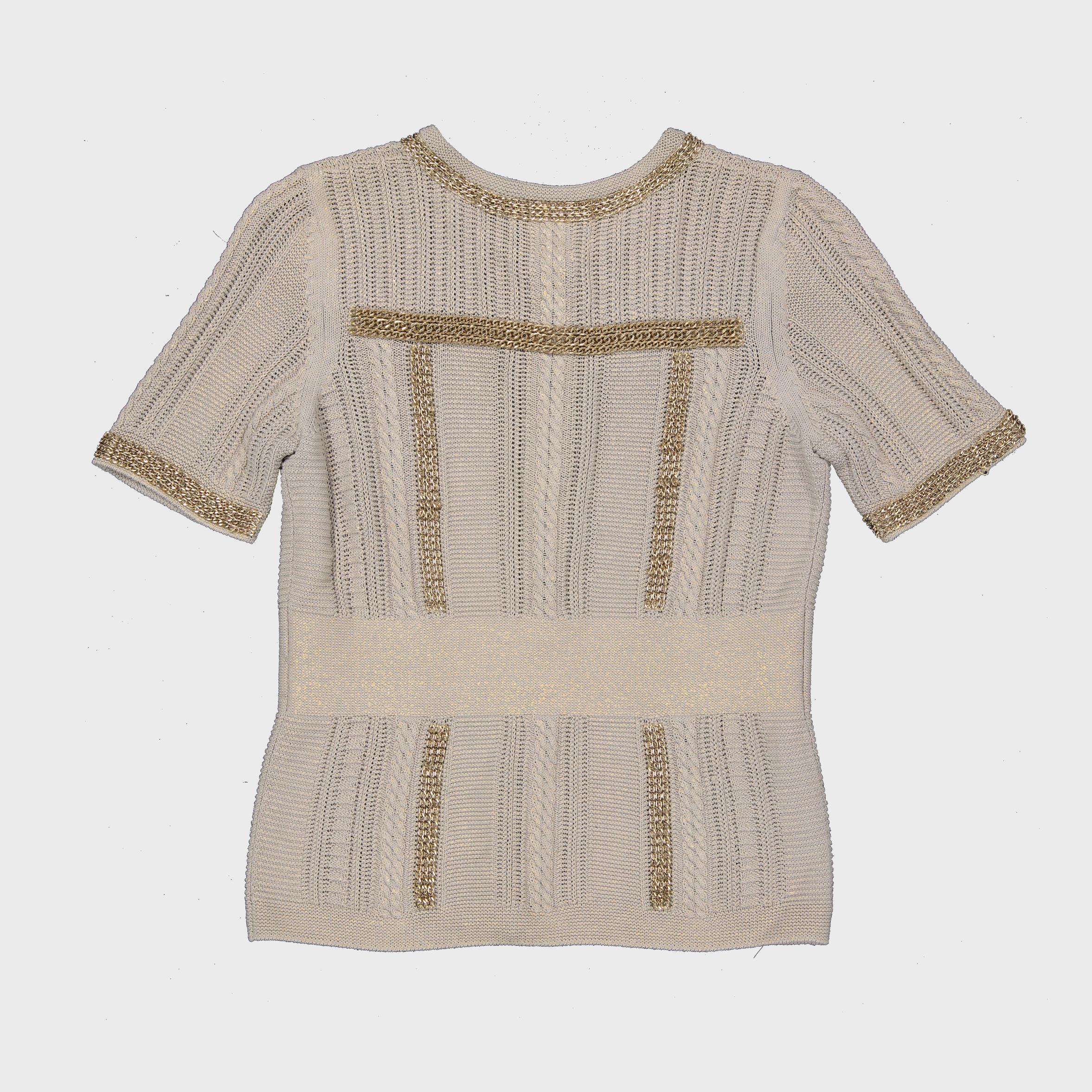 Issu de la collection printemps/été 2008 de Chanel, dessinée par Karl Lagerfeld, ce cardigan à manches courtes en maille métallique reflète l'esthétique à la fois élégante et moderne de la Maison. Confectionné en Italie dans un mélange de viscose et