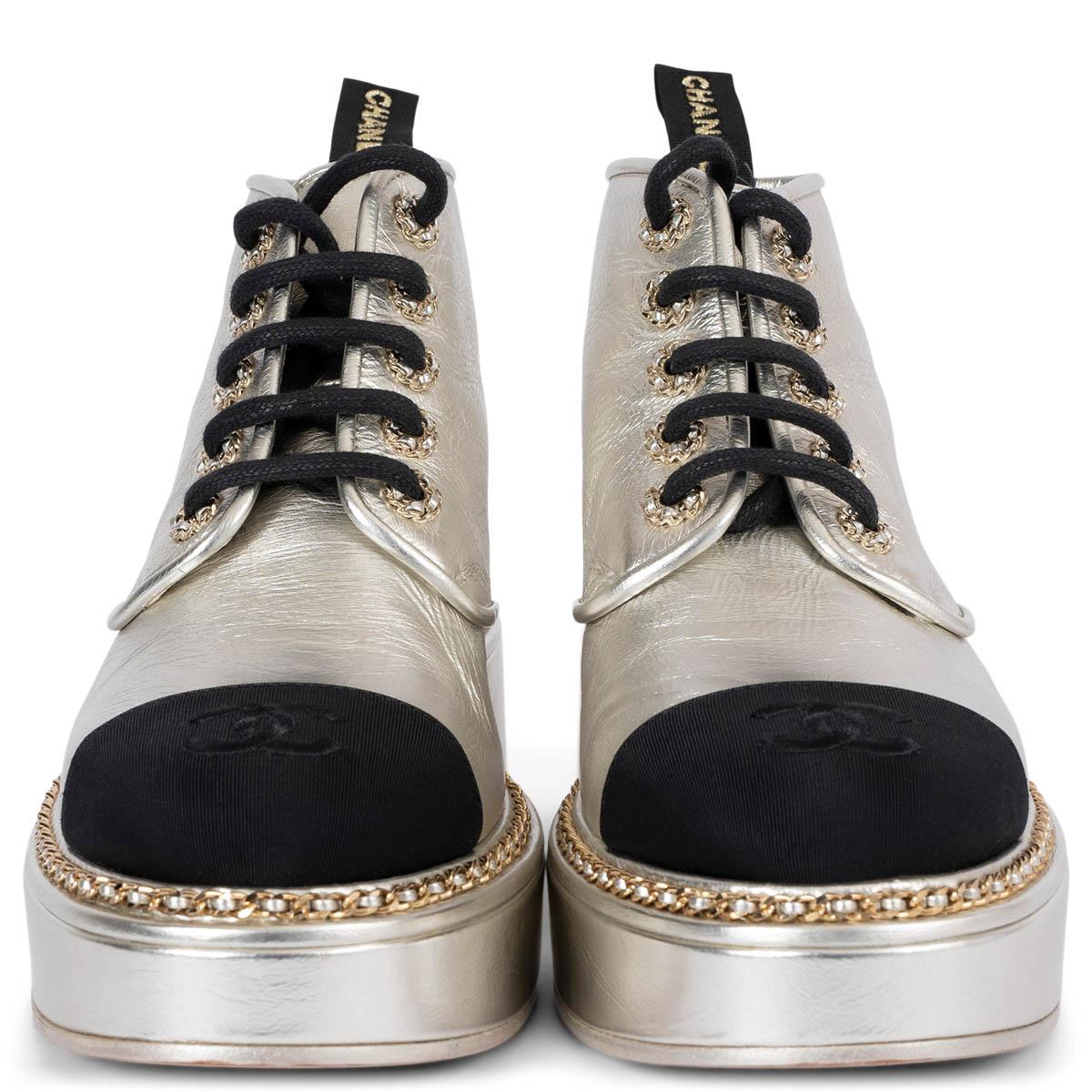 100% authentic Chanel platform lace-up ankle Booties in metallic silver leather embellished with a gold-tone chain, chain eyelets and classic black grosgrain cap toe. Have been worn once inside and are in virtually new condition. Come with dust bag.