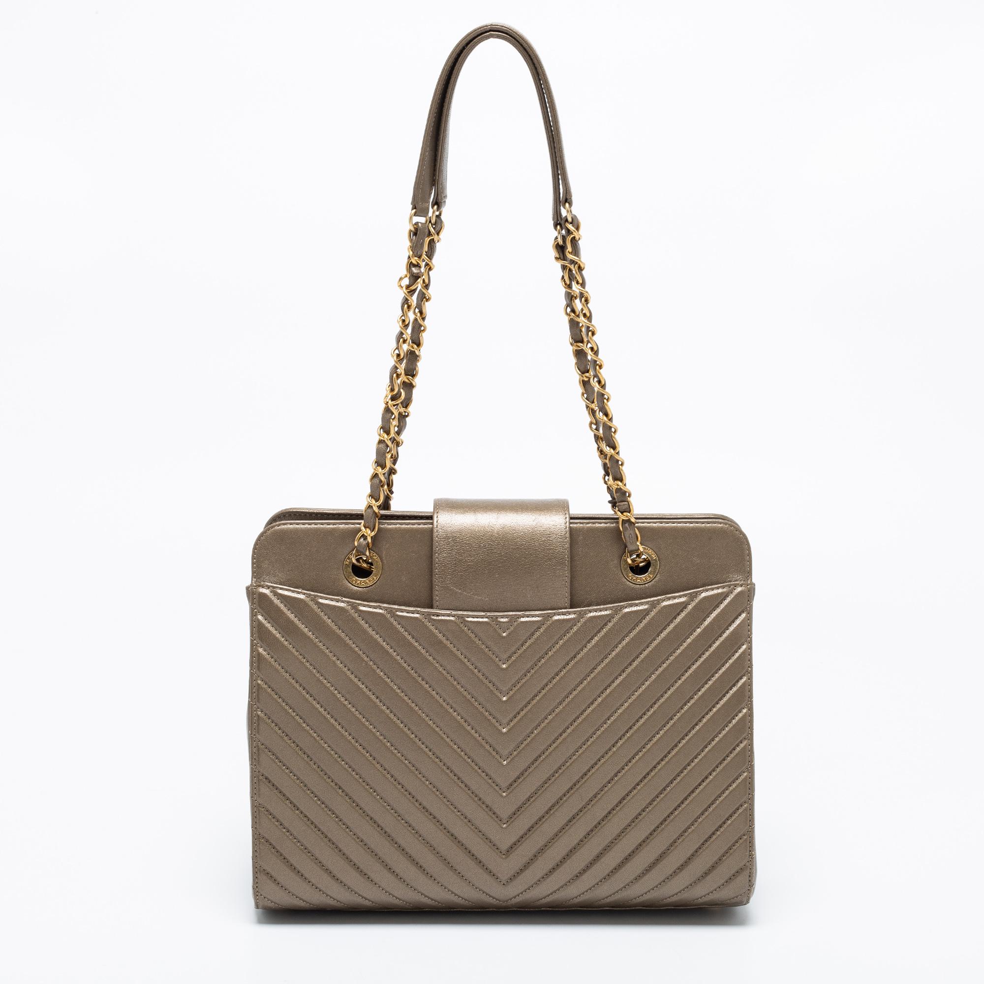 This Chanel Collar And Tie shoulder bag represents the label's contemporary and classy attributes. It is made from chevron-quilted leather in a classy metallic olive shade with the CC logo on the flap strap. The bag is complete with shoulder