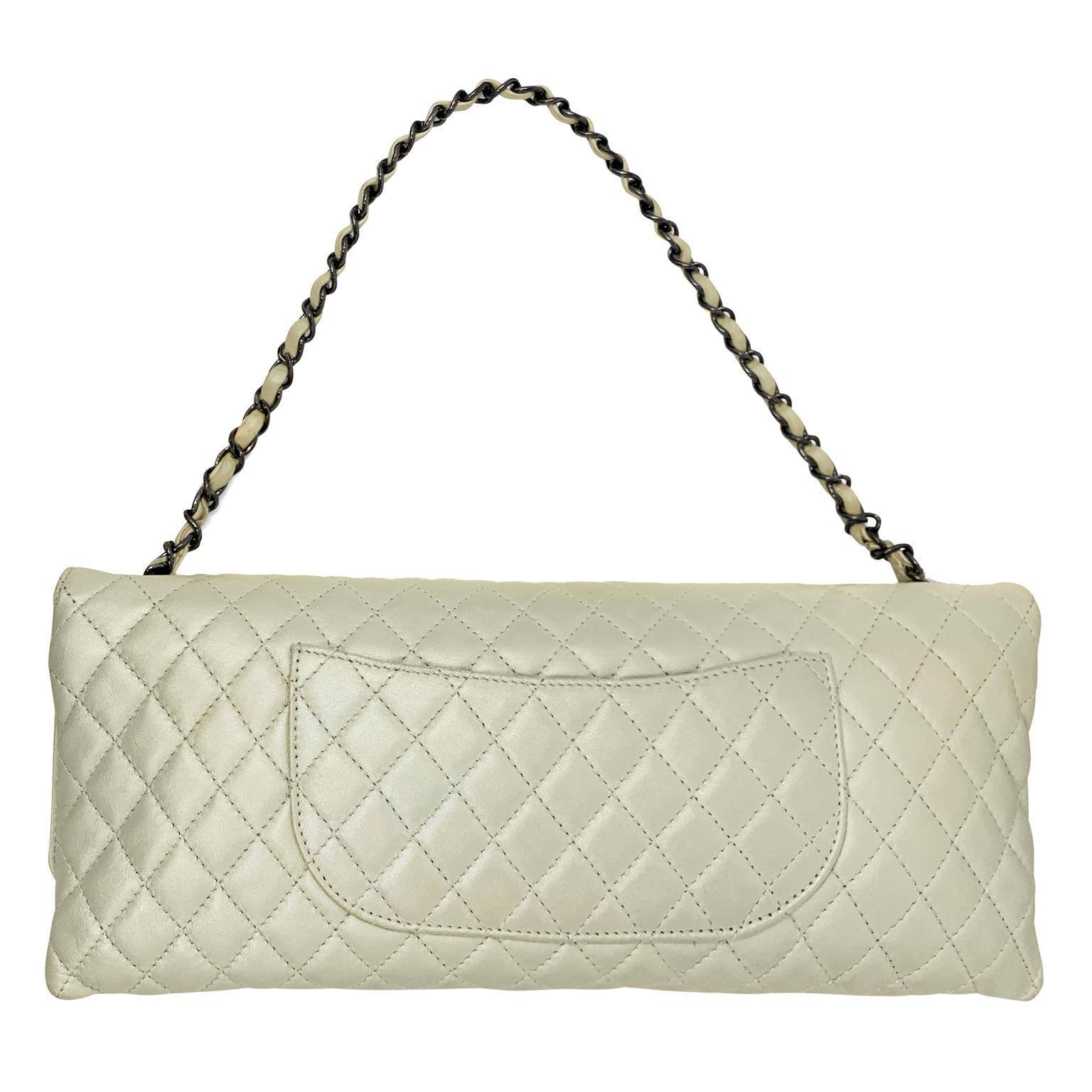 This authentic Chanel Metallic Pearl Leather East West Reissue Bag is in excellent condition.  Signature Chanel diamond quilted pearly white leather with subtle metallic sheen.  Fold over top has dark silver mademoiselle twist lock closure.  Single