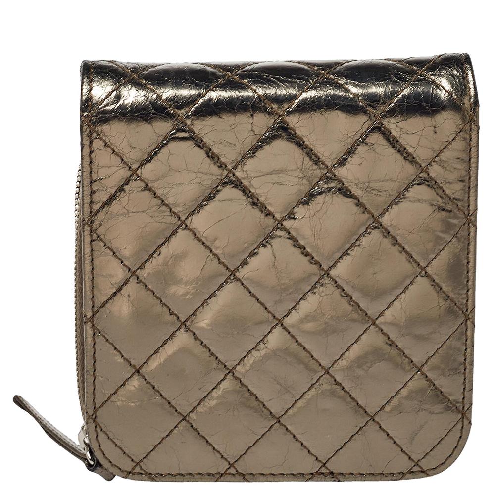 Diese sorgfältig entworfene WOC-Tasche ist eine Kreation von Chanel. Sie wurde aus goldfarbenem Metallic-Leder gefertigt und trägt das charakteristische Steppmuster. Das Innere ist sowohl mit Leder als auch mit Stoff gefüttert und die Tasche ist mit