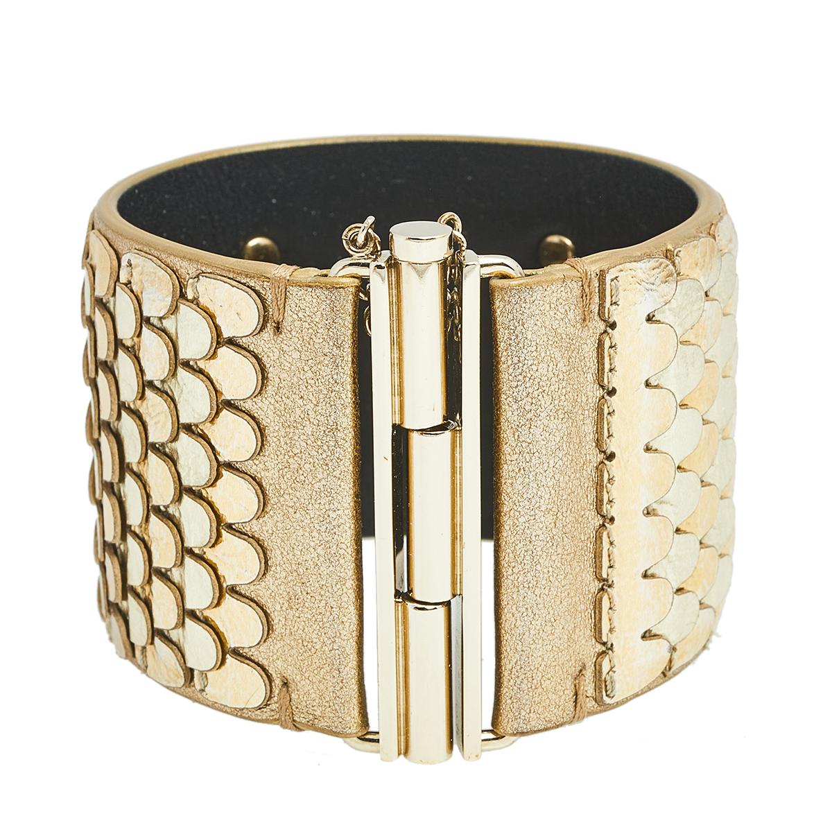 Created using gold-plated metal and metallic leather, this Chanel cuff bracelet has scale-like layers and the iconic CC logo. It's a signature Chanel style that you'll love wearing.
