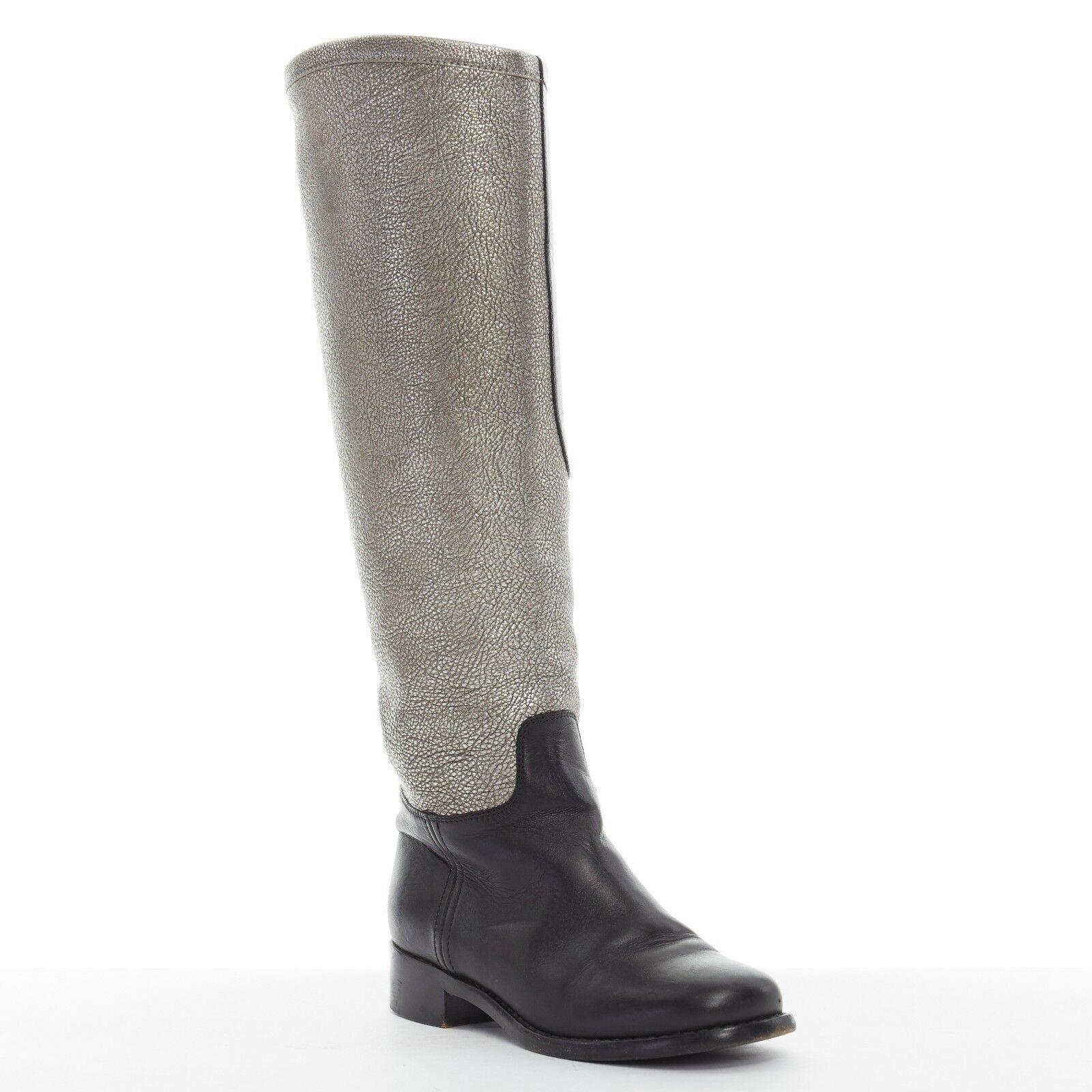 CHANEL metallic silver black leather color-blocked CC pull-on tall boots EU35.

CHANEL
Black leather upper. Metallic silver pebble leather shaft. Color blocked. CC logo stitching detail on shaft. Rounded toe. Stacked wooden heel. Pull on boots.