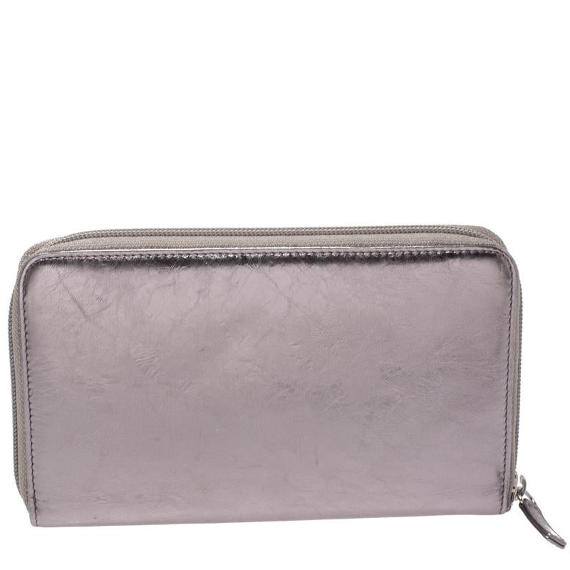 Infusing signature touches, this wallet from Chanel has a functional structure brimming with durability. It is crafted with metallic silver bow embossed leather. It comes fitted with a leather & fabric interior equipped with multiple card slots and