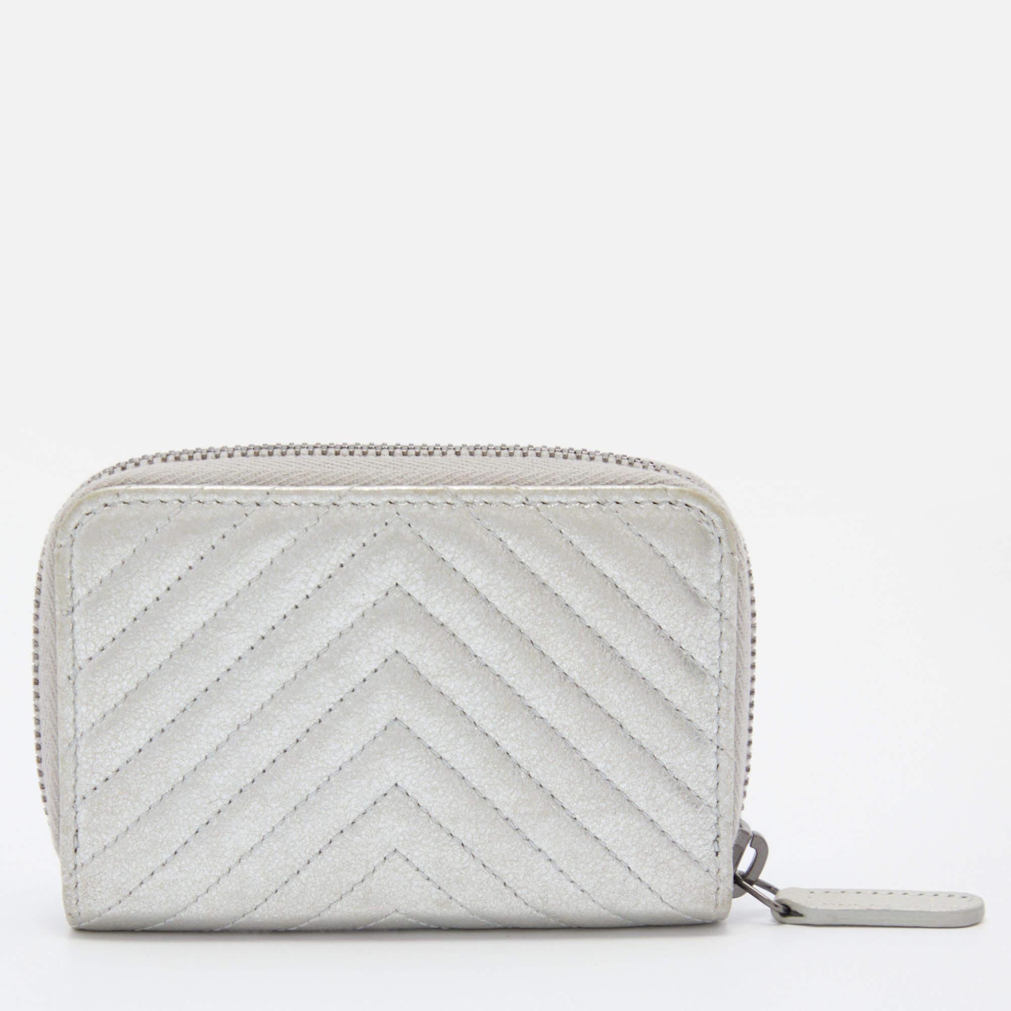 The compact silhouette of this Chanel coin purse makes it easy to fit into a tote. Created from quilted chevron leather, it flaunts a 'CC' motif on the front, a zip-around closure, and a fabric-lined interior.


