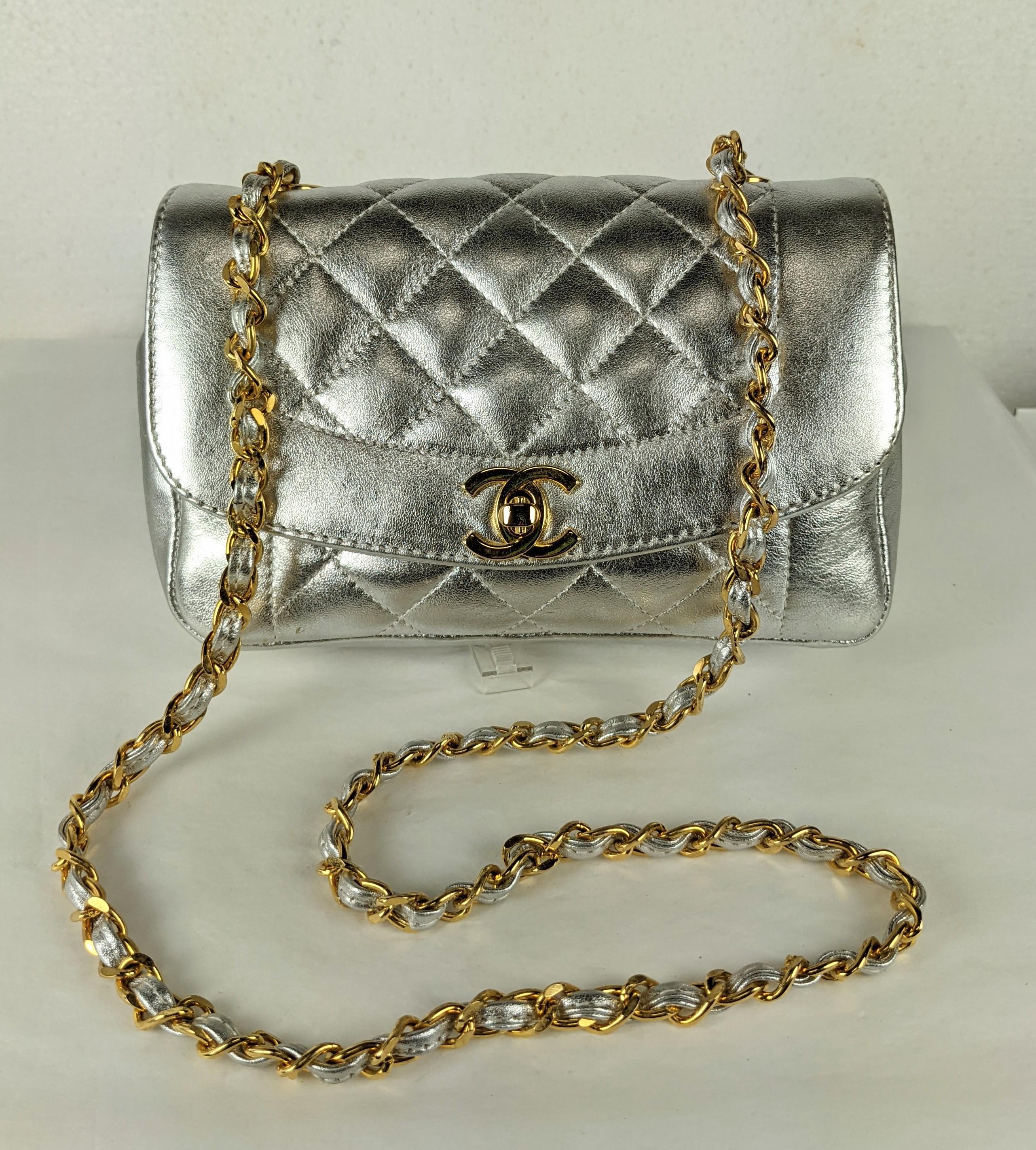 Unusual Chanel Metallic Silver Lambskin Shoulder Mini with black lining with original 24K gold plated hardware and original strap. Adorable mini size but a practical mini that can actually hold quite a lot (phones, wallets, etc.) 
1990's France w.