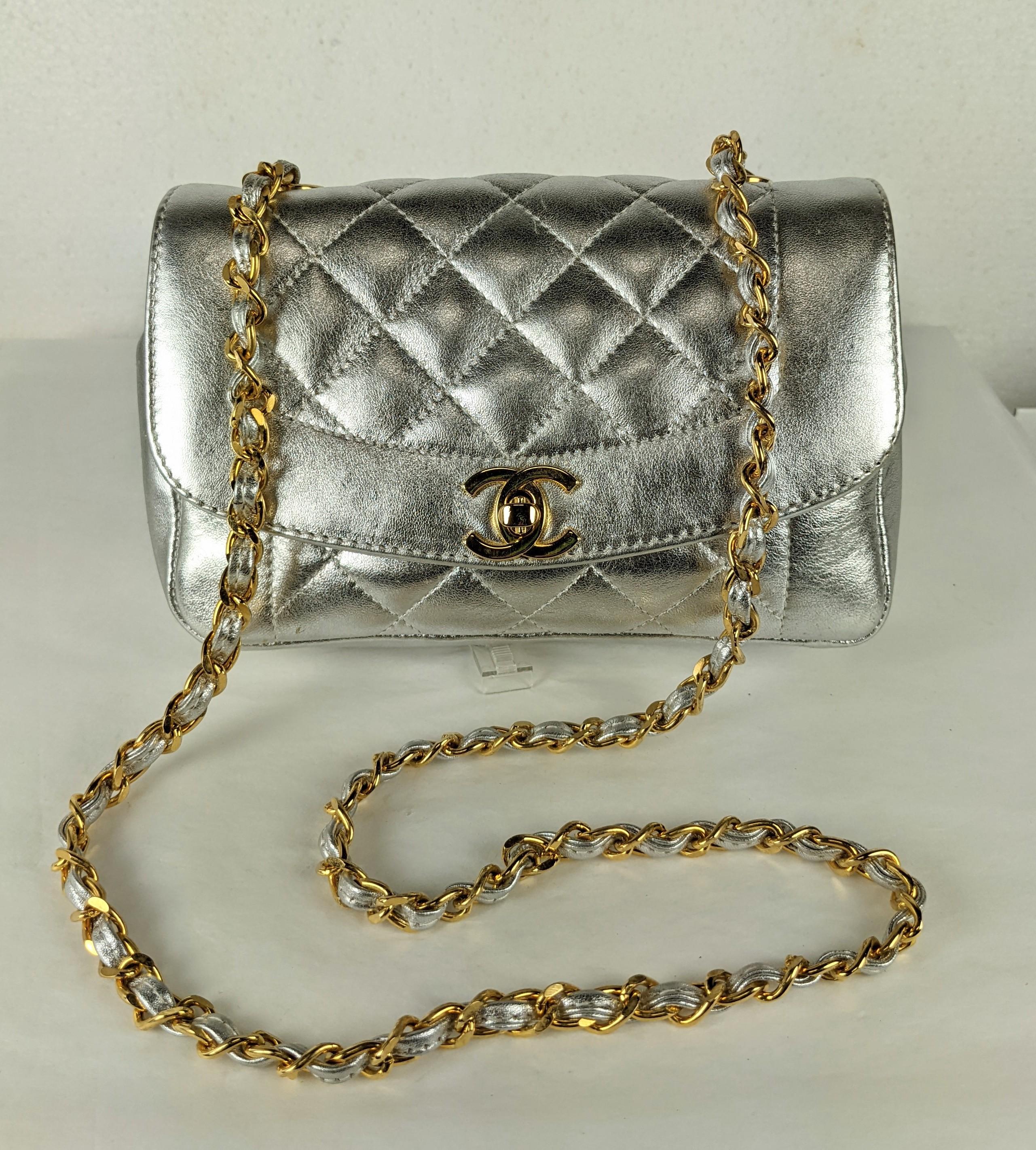Inhabituelle Mini épaule en agneau métallisé argenté de Chanel, doublée de noir, avec le matériel d'origine plaqué or 24K et la bandoulière d'origine. Un format mini adorable mais un mini pratique qui peut en fait contenir pas mal de choses
