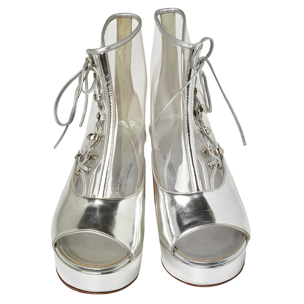 Your dream of owning a pair of Chanel booties can come true with these ones that are hard to miss! They are crafted from metallic silver leather in an open toe silhouette and designed with PVC panels and solid platforms. They feature lace-ups on the