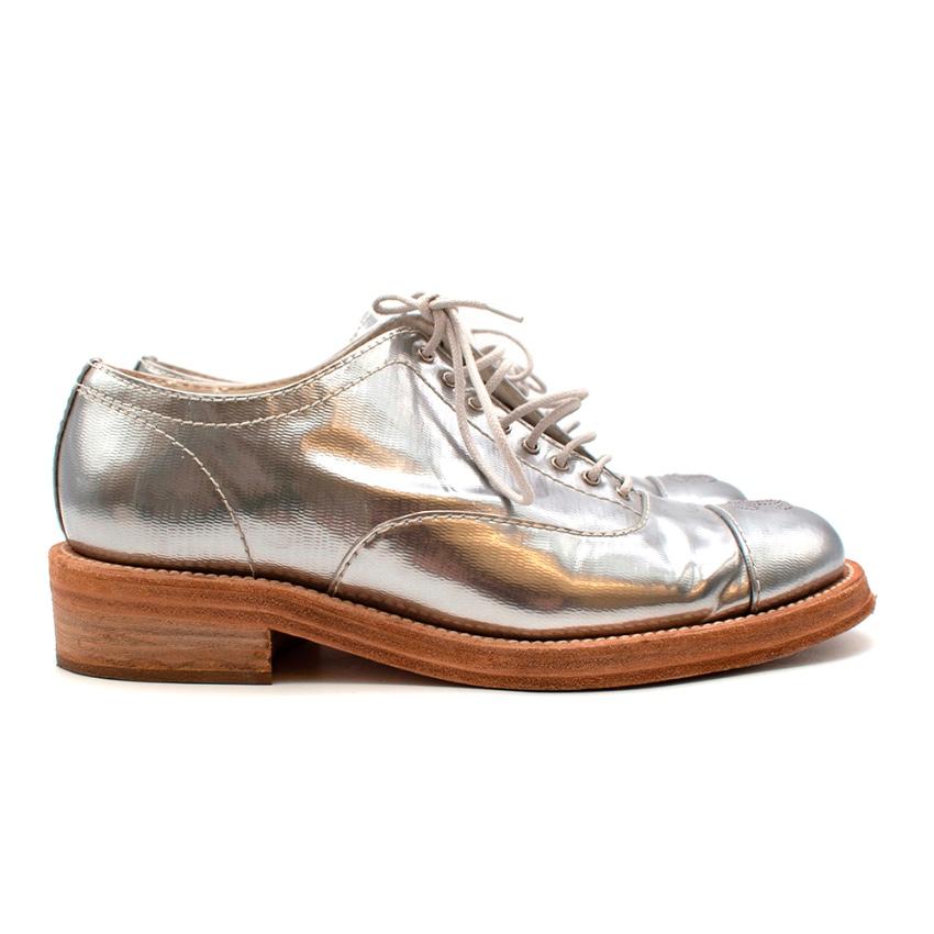 Chanel Metallic Silver Leather CC Brogues 

-Iconic CC logo to the toes
-Gorgeous coated silver leather 
-Luxurious soft leather lining 
-Lace-up fastening to the front
-Natural leather soles 

Materials:
Main- coated leather 
Lining- leather