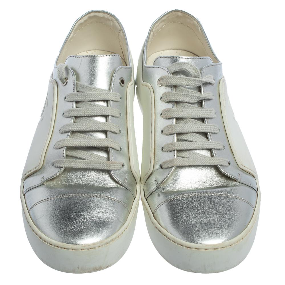 Exude high style in these super-stylish sneakers from the house of Chanel! They are carefully crafted from metallic silver leather as well as white rubber, and designed with laces on the vamps. You are sure to receive both comfort and fashion when