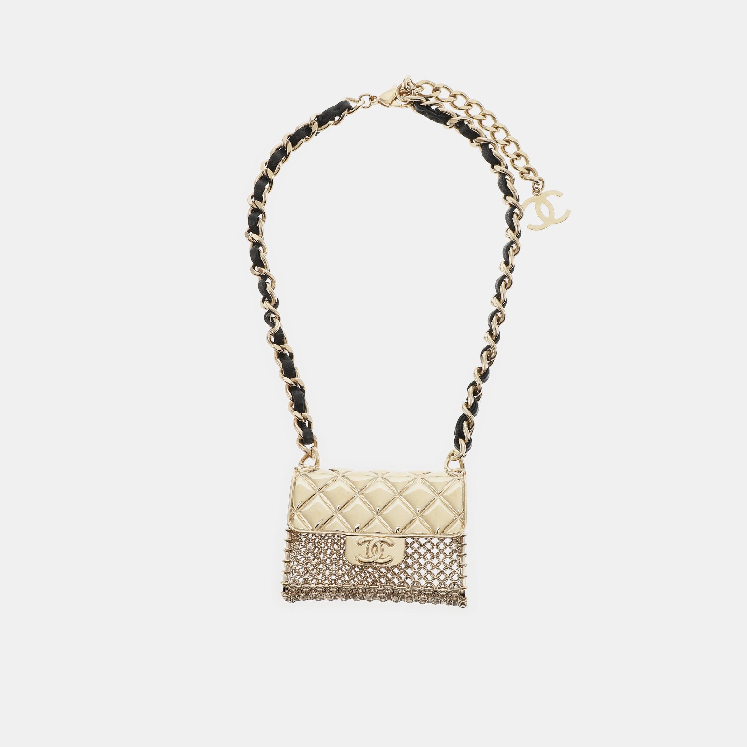 El Collar Gargantilla con Cadena Chanel Micro Flap Bag Charm combina a la perfección la esencia de las joyas y los bolsos de la icónica marca. Esta pieza de coleccionista, elaborada con anillos metálicos dorados intrincadamente enlazados, tiene una