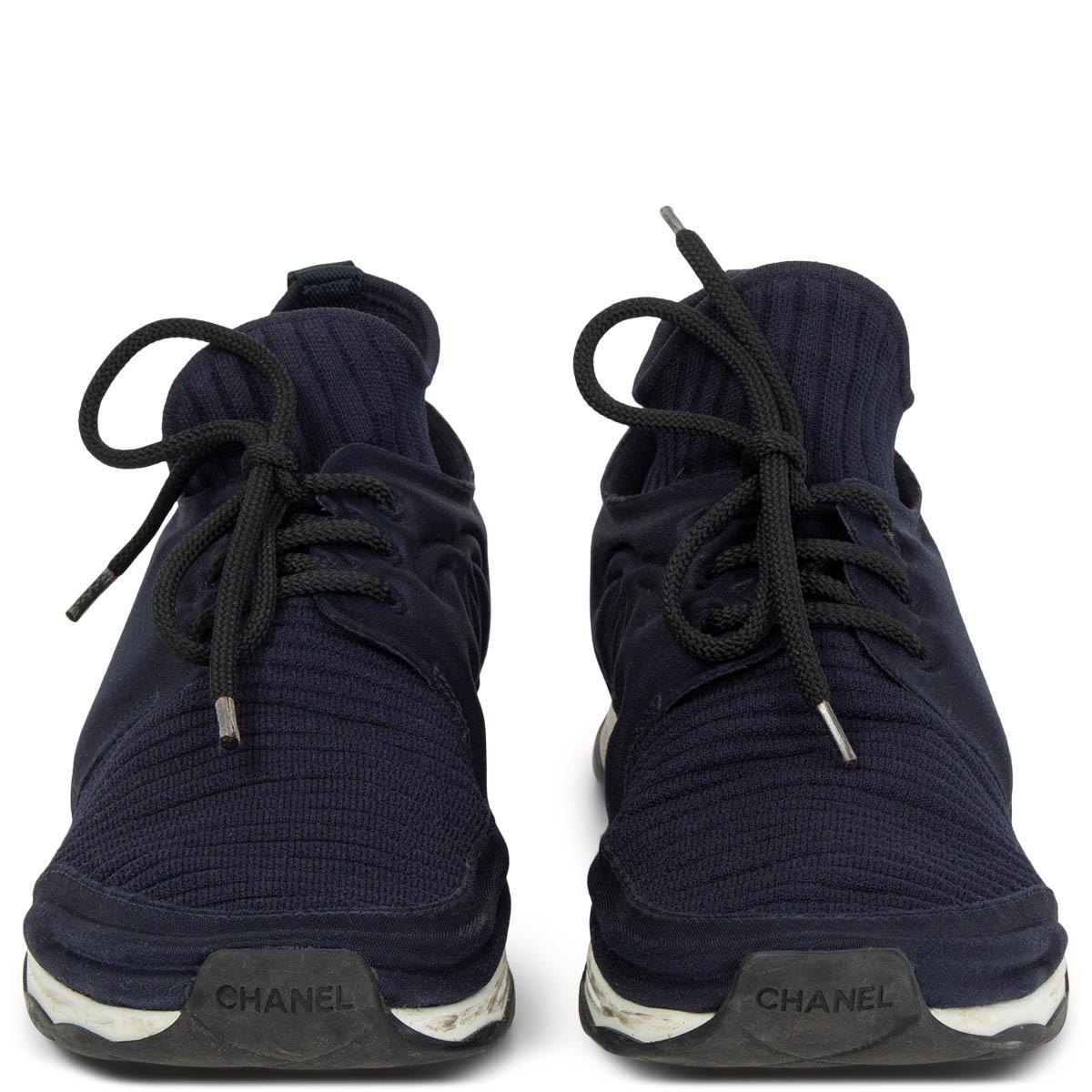 100% authentic Chanel lace-up stretch-knit sock speed sneakers in midnight blue elastic ribbed jersey and neoprene featuring a white rubber sole. Have been worn and CC logo print on pull-tab are removed, grey part of the lining shows a small part