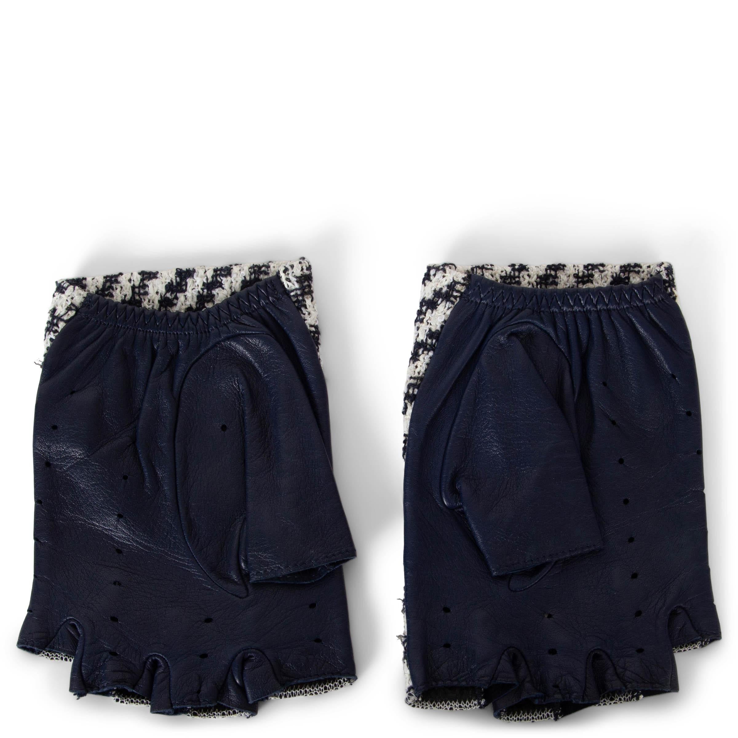 These 100% authentic Chanel fingerless gloves combine elegance and functionality, crafted in diagonally striped tweed in midnight blue and white with a midnight blue leather underside. Designed with an elastic band fastener for a secure fit, they