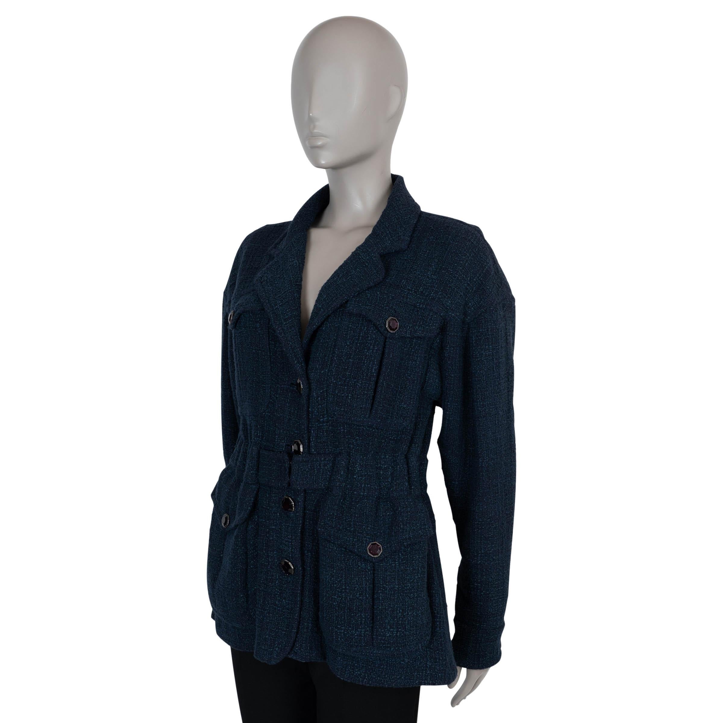 Questa giacca Chanel autentica al 100% in tweed di cotone (90%) e rayon (10%) blu notte presenta una silhouette oversize e senza sforzo, con spalle scese e vita stretta accentuata da una cintura abbinata. Caratterizzato da rever a specchio e quattro