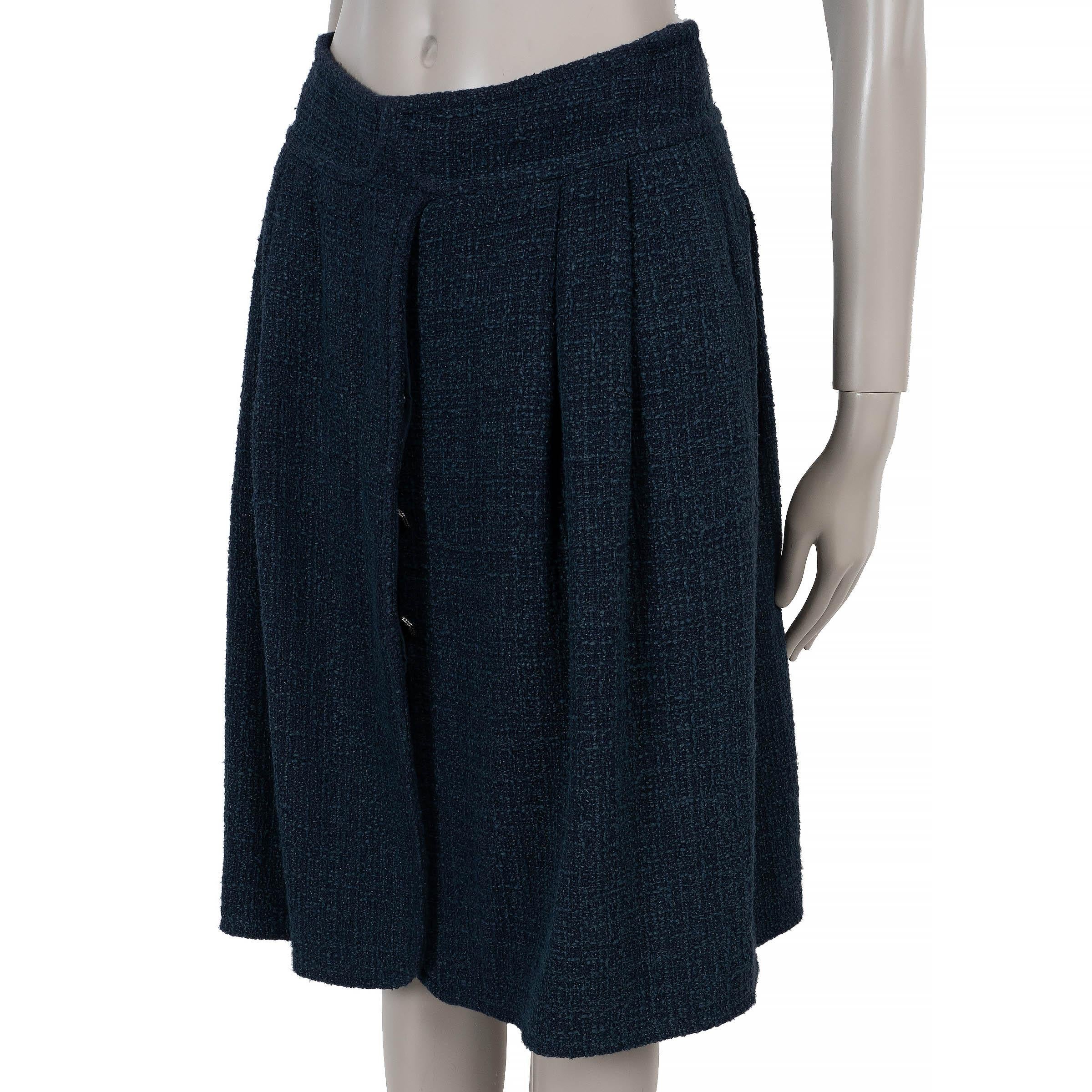 Questa gonna Chanel 100% autentica in tweed di cotone (90%) e rayon (10%) blu notte cattura la raffinata eleganza della Maison. Progettato con una silhouette svasata e lunga fino al ginocchio, presenta morbide pieghe, due tasche e un davanti