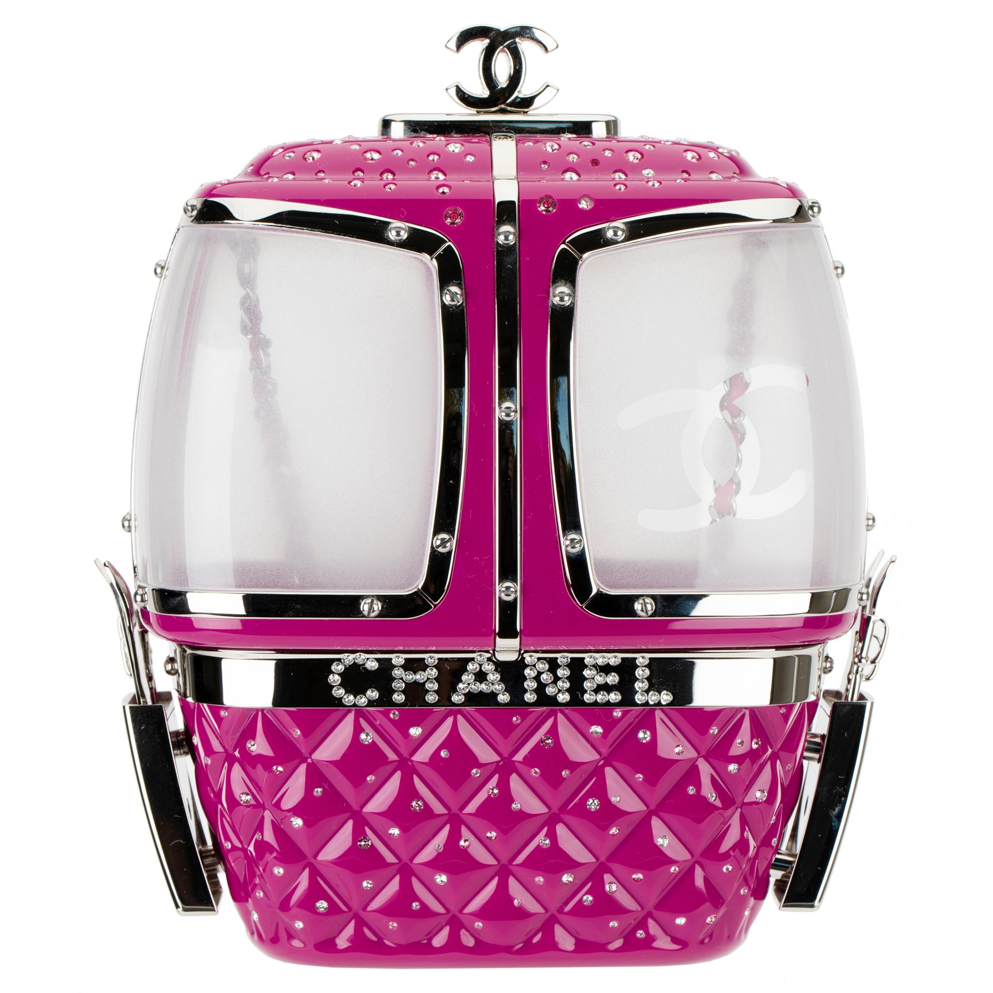This Ski Gondola Minaudière or, more familiarly known known as a cable cars, from the ski resort themed Fall/Winter 2019 collection is made from fuchsia lucite, with silver tone hardware and rhinestones decorated throughout. Look closely, and you’ll