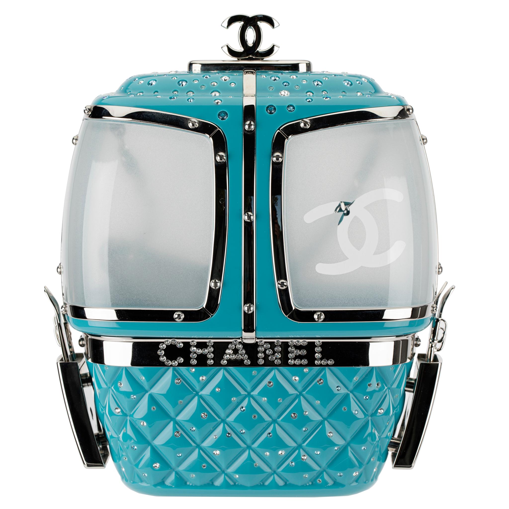 This Ski Gondola Minaudière or, more familiarly known known as a cable cars, from the ski resort themed Fall/Winter 2019 collection is made from turquoise lucite, with silver tone hardware and rhinestones decorated throughout. Look closely, and