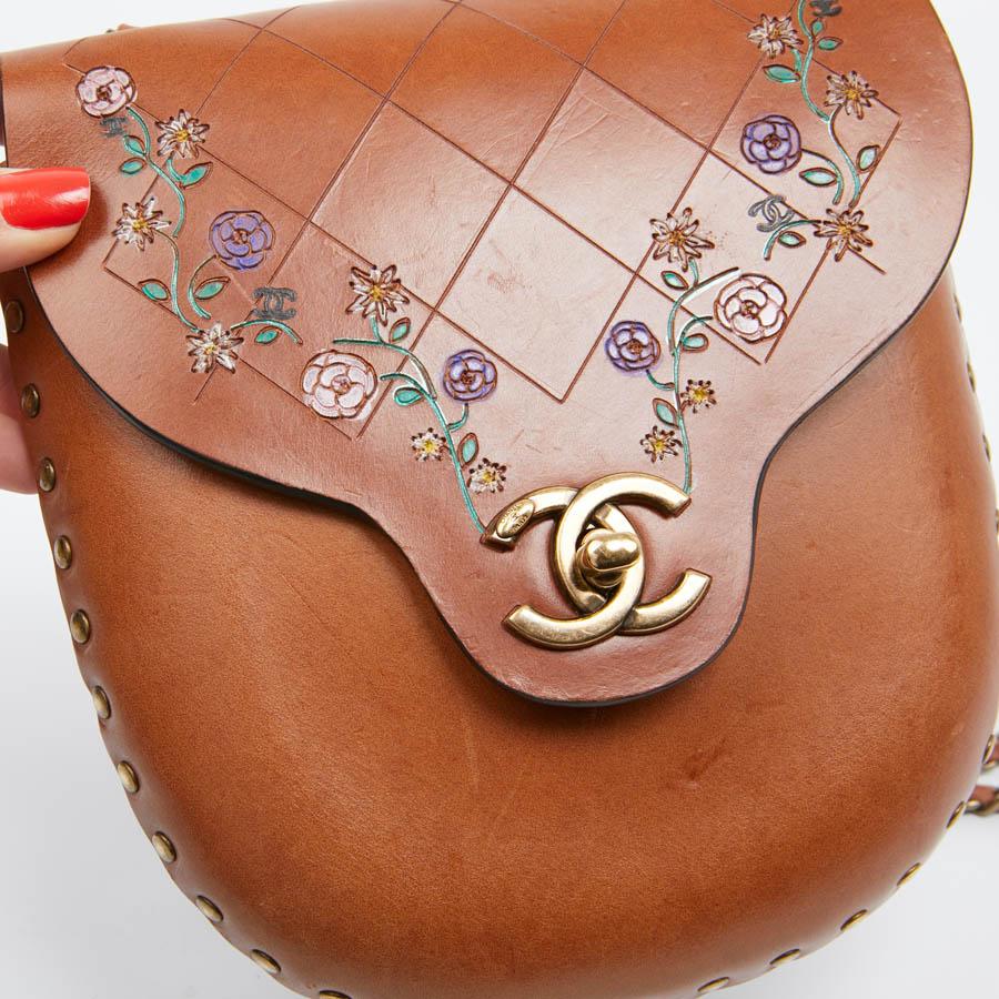 Collector. Mini bag in natural cowhide leather and natural gold color. Karl LAGERFELD had created a Collection in Texas. At the front of the bag are  painted camellia flowers. Presence of the symbolic 