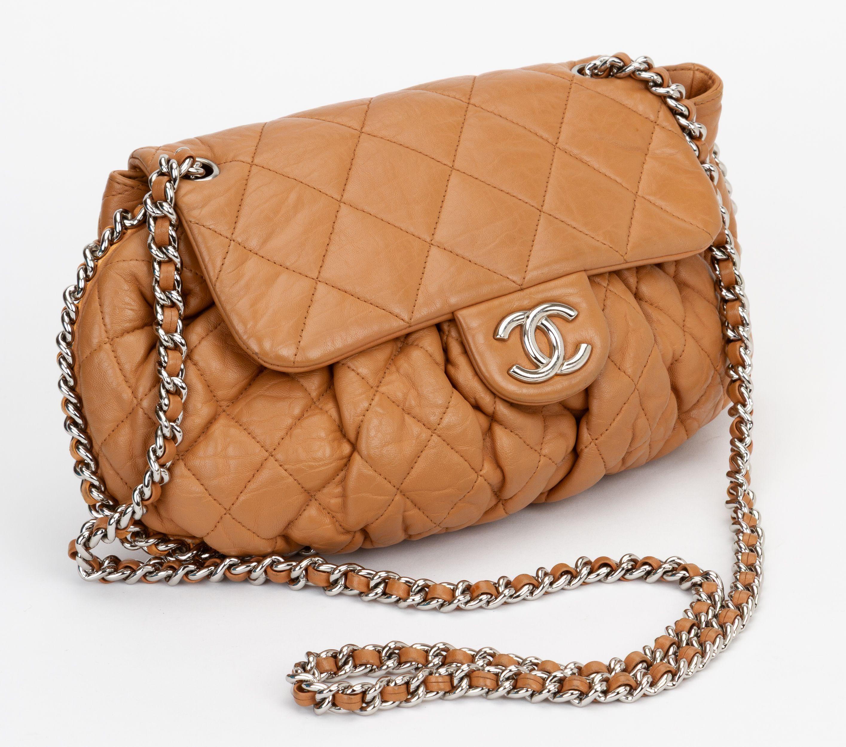 Borsa a tracolla Chanel in pelle d'agnello color caramello con logo CC a incastro, motivo trapuntato, finiture color argento, spallacci a catena, fodera in gros-grain e un'unica tasca interna con chiusura a scatto.