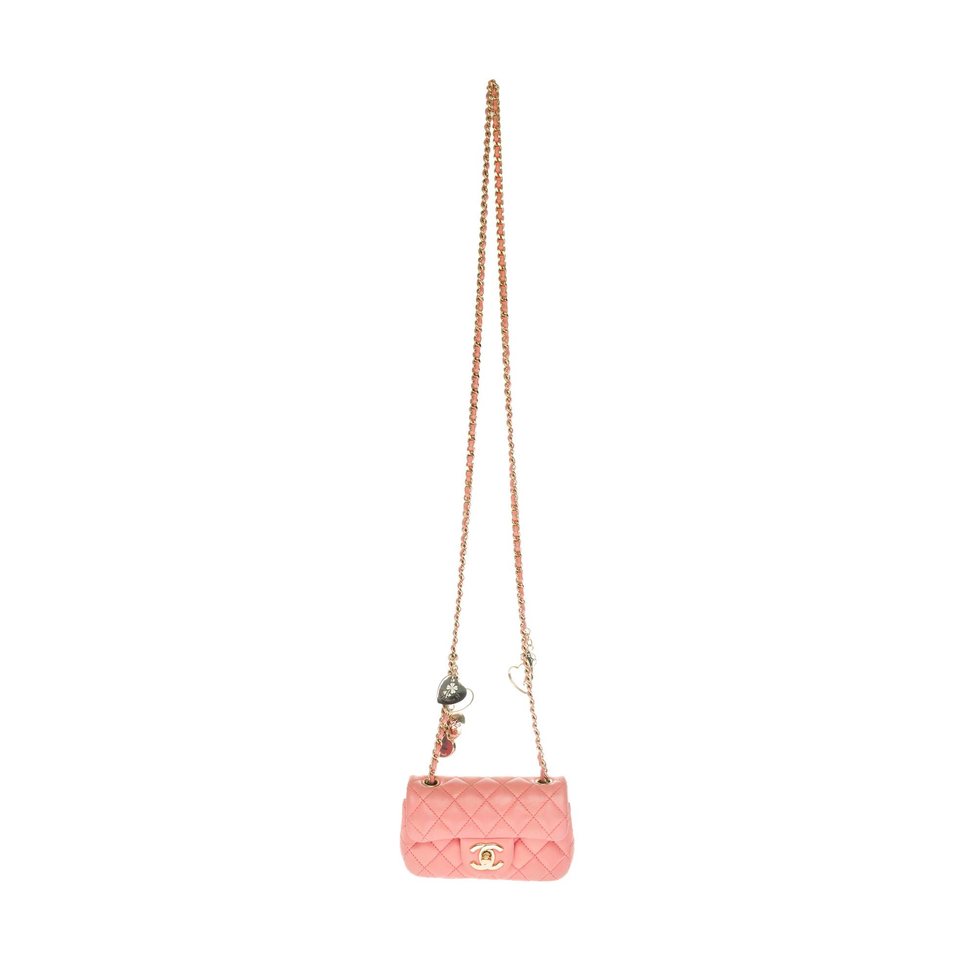 The very Gorgeous and highly coveted Chanel Mini Charms Flap bag in pink quilted leather, gold metal shoulder strap handle decorated with heart-patterned charms (Valentine charms) intertwined with pink leather for a shoulder or shoulder