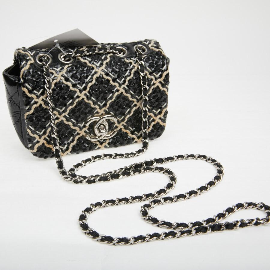 CHANEL Mini Flap Bag in Black Patent Braided Leather.
It is in patent leather braided in superposition on a smooth black leather. It is embroidered with a beige cord thread. The hardware is in palladium silver metal. The interior is lined in black