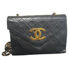 CHANEL - Mini-pochette en cuir noir avec logo CC doré surdimensionné (années 1980)