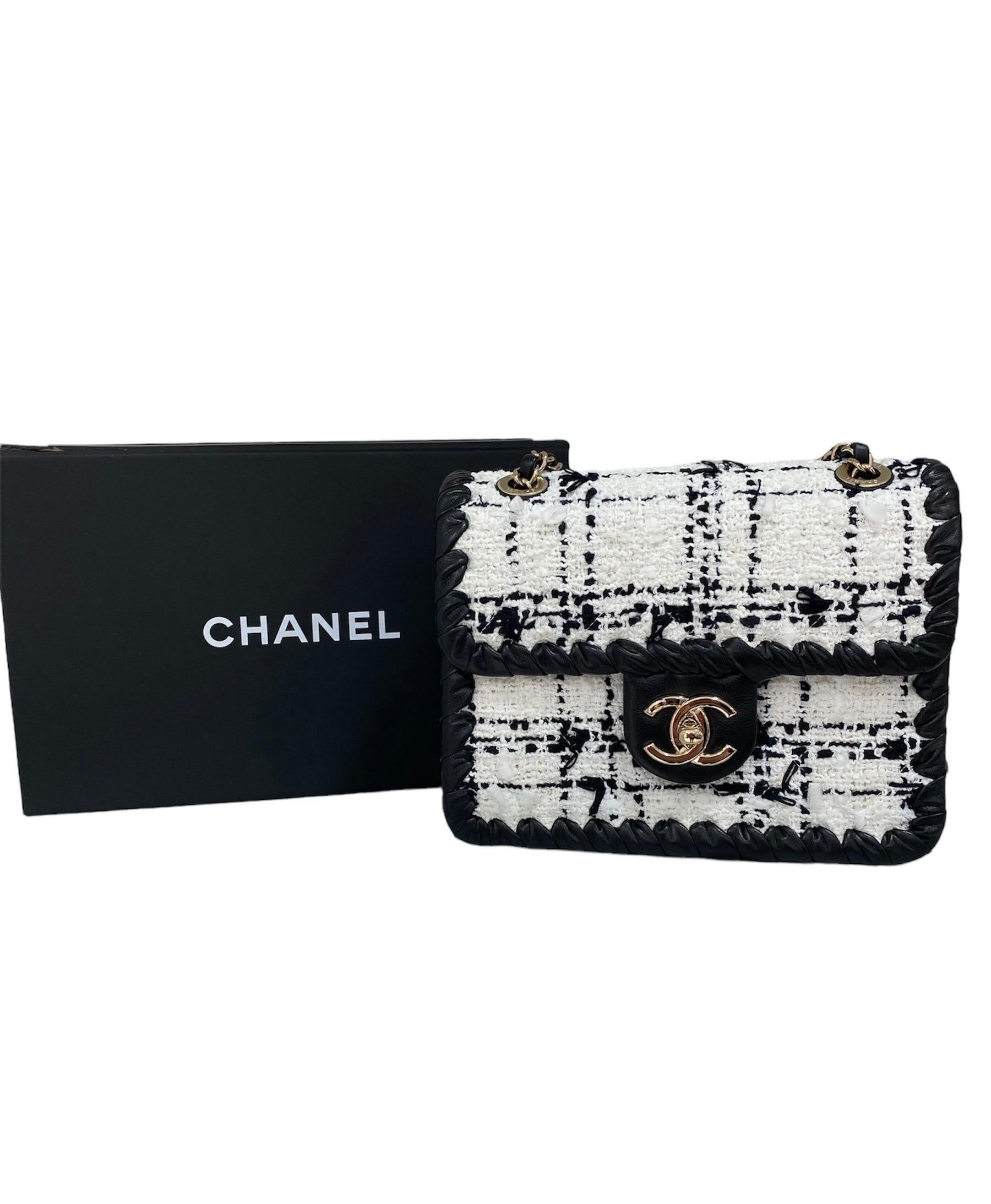 Chanel signed bag, Mini Flap model, made of black and white tweed with black leather inserts and silver hardware.

Equipped with a flap with CC logo closure, internally lined in black fabric, roomy for the essentials.

Equipped with a sliding