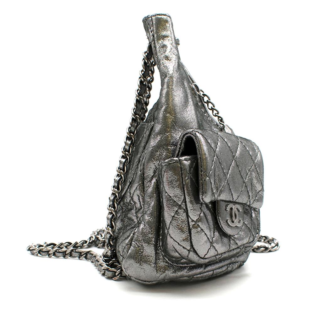 Chanel Mini Silver Split-Zip Backpack

-Dark silver, glitter-effect fabric 
-Gunmetal hardware
-Chain and woven fabric shoulder strap 
-Quilted fabric front cargo pockets, CC press-stud hardware 
-Back-zip pocket 
-Front split-zip closure 
-Black