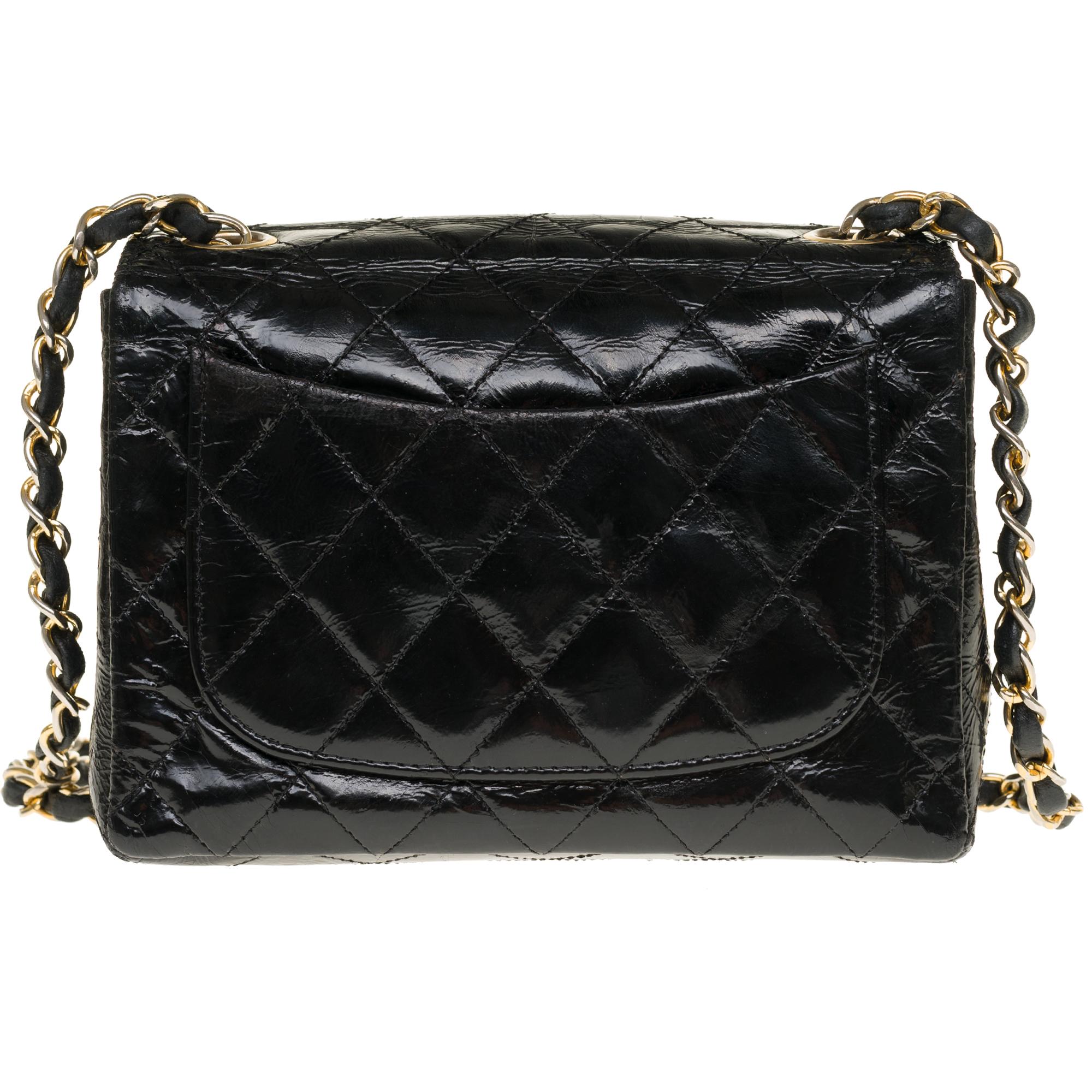 Gorgeous and highly sought-after Chanel Mini Timeless bag in black quilted patent leather, gold-tone metal shoulder strap handle intertwined with black patent leather.
Closure by flap and closure by tourniquet in gold metal.
Inside in burgundy