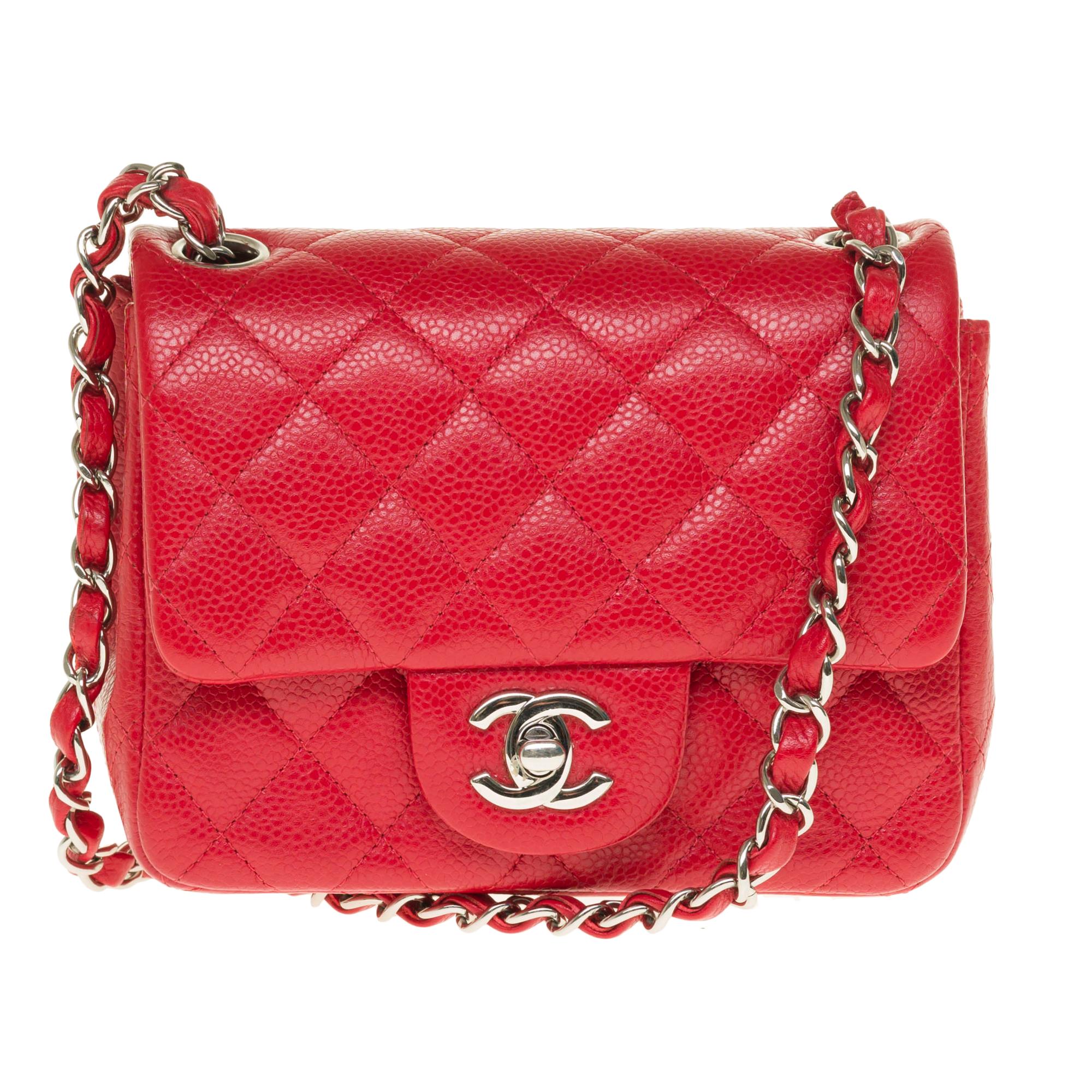 Stunning Mini square Chanel Timeless handbag in red caviar leather, chain handle intertwined with red leather allowing a hand or shoulder or shoulder strap.

Silver metal flap closure.
A patch pocket on the back of the bag.
Lining in red leather, a