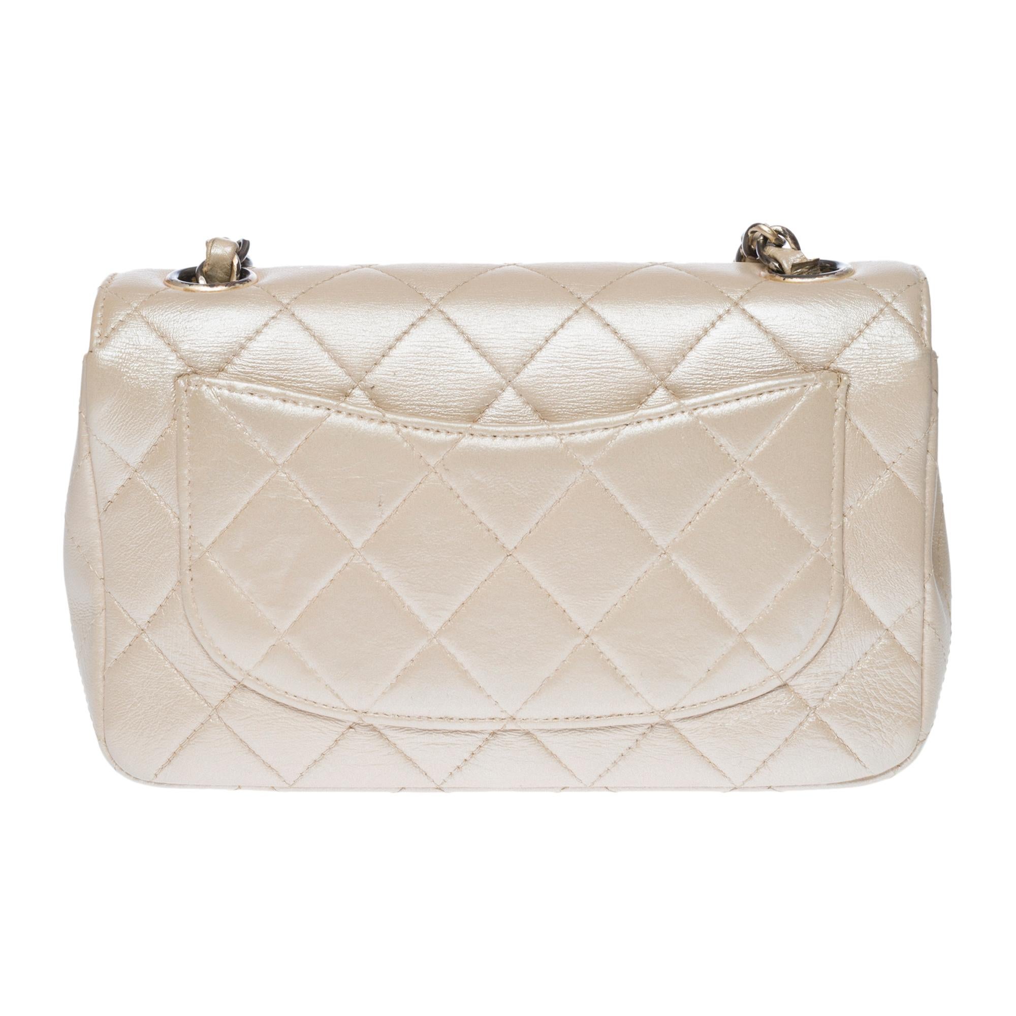 Rare Chanel Timeless Mini flap shoulder bag in metallic mother-of-pearl quilted leather, gold-plated metal hardware, a gold-plated metal chain handle interlaced with metallic mother-of-pearl leather for hand, shoulder or crossbody support

CC