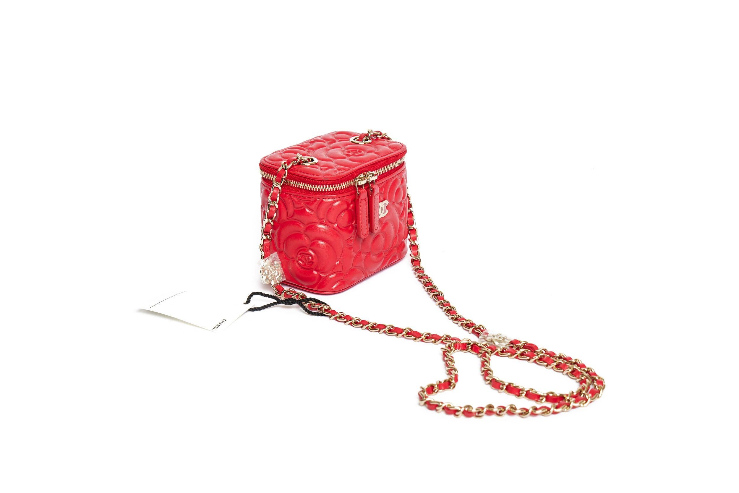 Chanel Mini Vanity Case bag in red with embroidered Camellia pattern. This bag is brand new so that the small flowers on the shoulder leather-threaded gold chain (drop 22’) are still covered in plastic. The bag closes with a zip and in front is the