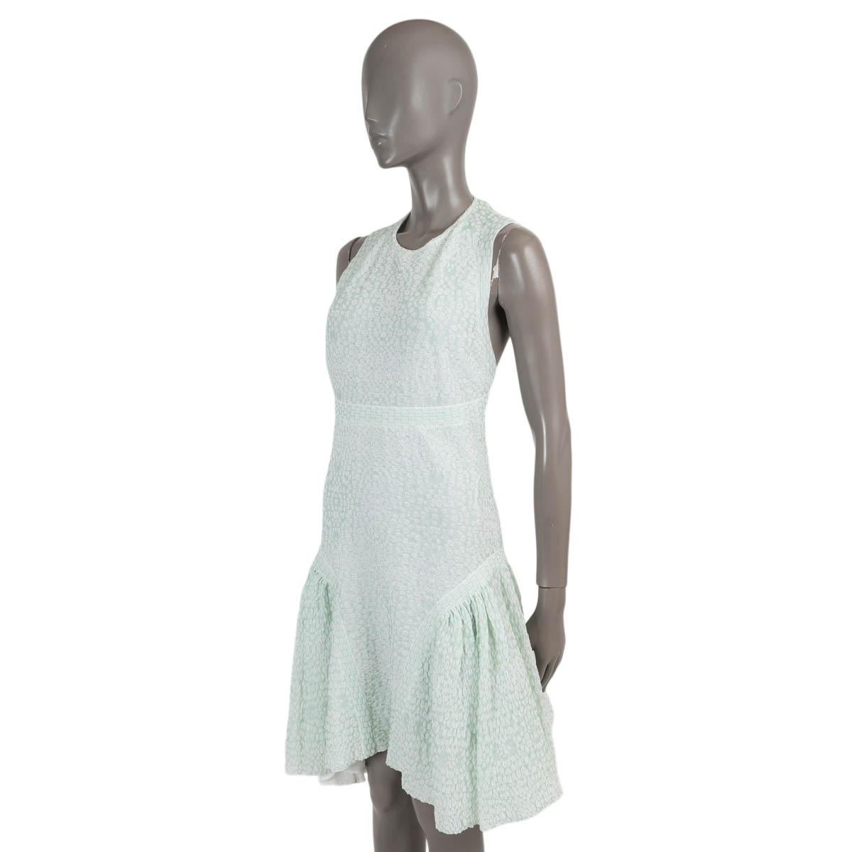 100% autentico abito Chanel in maglia testurizzata verde menta e avorio in cotone (63%) e poliammide (37%). Presenta un girocollo, un orlo a rete e una schiena a raggiera. Si chiude con un bottone di finta perla al collo. Sfoderato. È stato