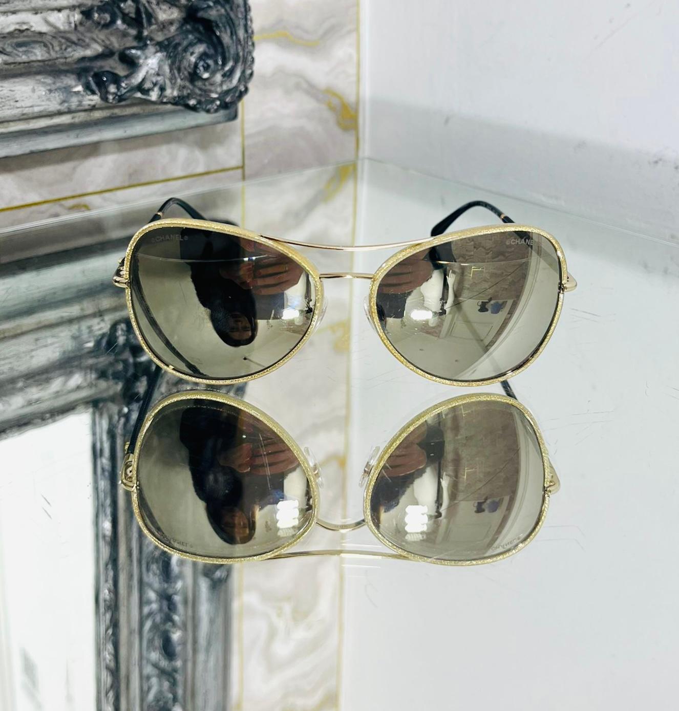 Chanel Mirrored Pilot Sunglasses

Aviator sunglasses designed with sparkling gold, textured frames.

Styled with brown, mirrored lenses and black arms.

Featuring gold 'CC' logo detailing to the side.

Size – One Size 

Condition – Good (Light