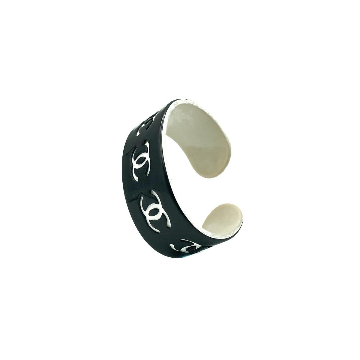 A  Chanel Monochrome Logo Cuff. Featuring an arc style design embellished with the iconic CC logo from end to end. 
Since 1910 when Gabrielle 'Coco' Chanel opened her first boutique, the House of Chanel boasts a heady timeline.  Invest in this