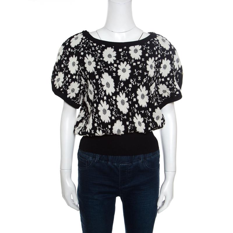 Beautifully designed to a relaxed shape, this Chanel top is a stunning casual separate. It comes crafted from a cotton blend in a monochrome hue and has a broad ribbed hem. It features short sleeves and a round neck. The creation, adorned with