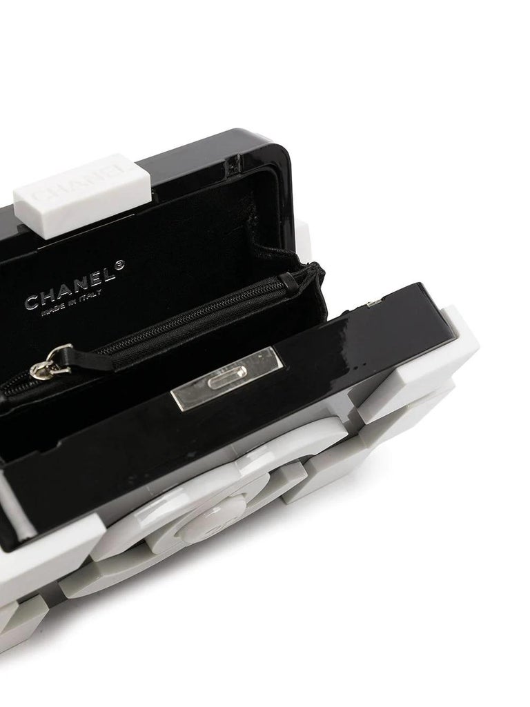 First released in 2012, the Chanel Lego bag is still one of the most sought after bags today. This rare and collectable pre-owned clutch bag is formed of monochromatic black and white plexiglass. Featuring prominent logos across both sides of its