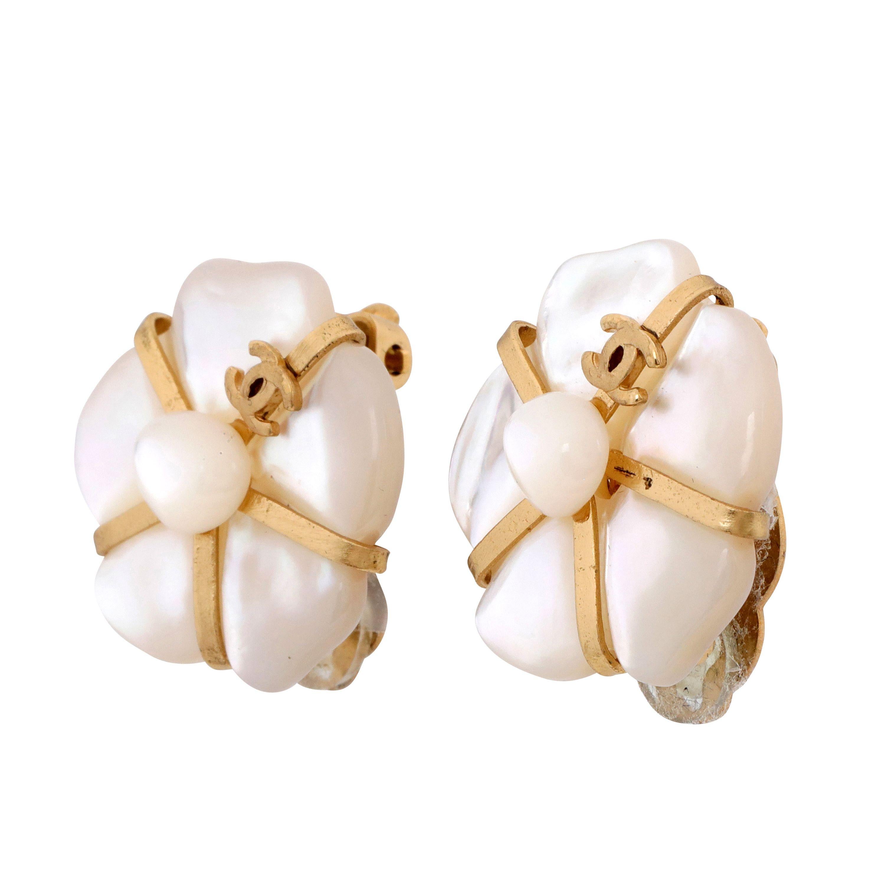 These authentic Chanel Mother of Pearl Camellia Earrings are pristine from the 2001 Fine Jewelry collection.  Abstract mother of pearl camellia flower center with gold. Clip on style.     Pouch or box included. 
PBF 13795
