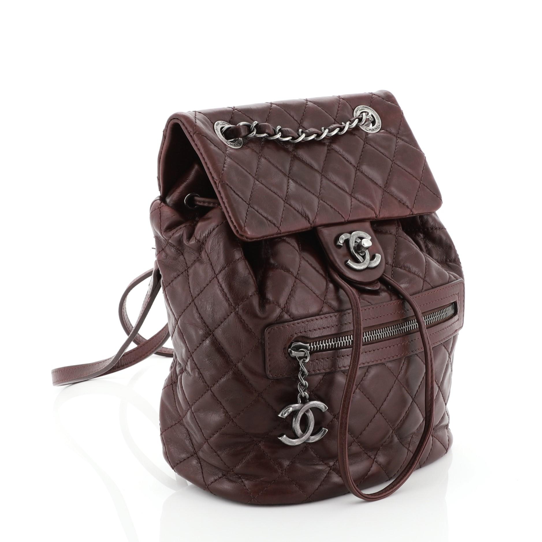 This Chanel Mountain Backpack Quilted Glazed Calfskin Small, crafted from red quilted glazed calfskin, features woven-in leather chain top handle, flat leather backpack straps, an exterior front pocket with CC logo zipper, exterior back slip pocket