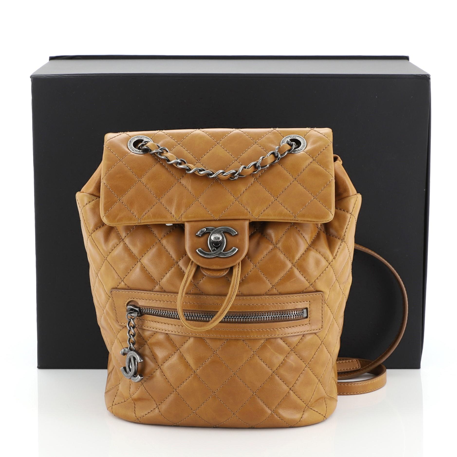 This Chanel Mountain Backpack Quilted Glazed Calfskin Small, crafted from yellow quilted glazed calfskin, features woven-in leather chain top handle, flat leather backpack straps, exterior front pocket with edelweiss CC logo zipper, and aged