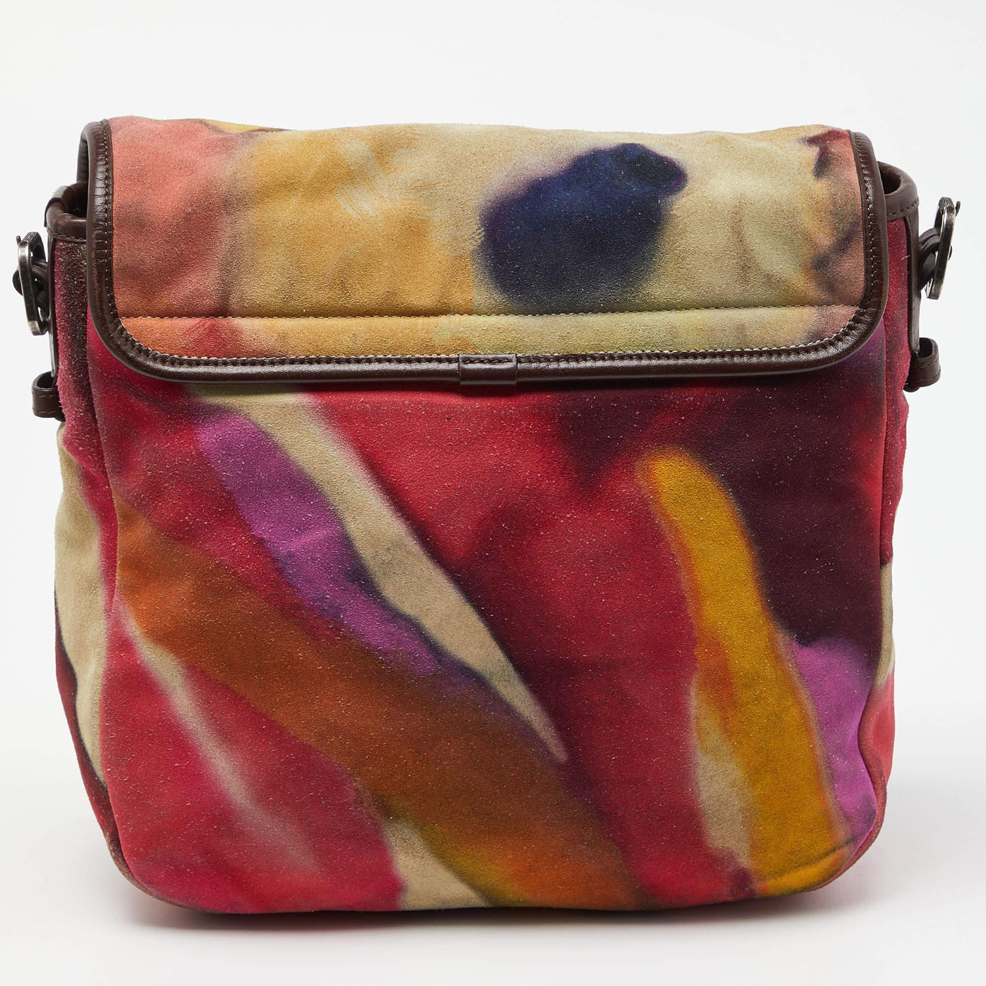 Constructed in multicolored Nubuck leather, this Chanel Flower Power messenger bag comes with a long shoulder strap that features the CC logo, peace symbol, and signature Camellia flower. It has an interior that is roomy enough to hold all your