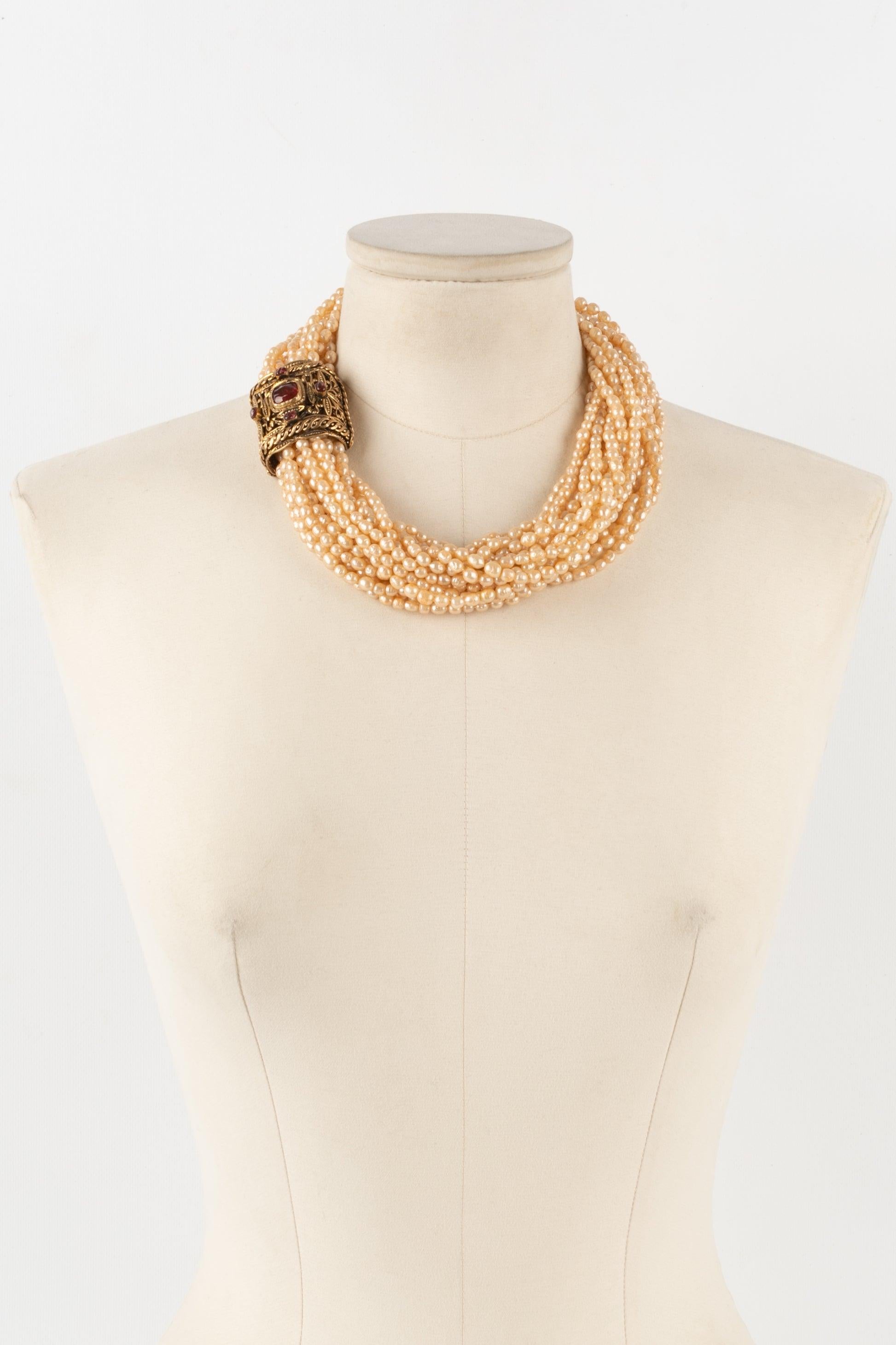 Chanel - (Made in France) Multi-row choker composed of costume pearls, red glass paste, and an openwork golden metal fastener.

Additional information:
Condition: Very good condition
Dimensions: Length: 47 cm

Seller reference: CB147