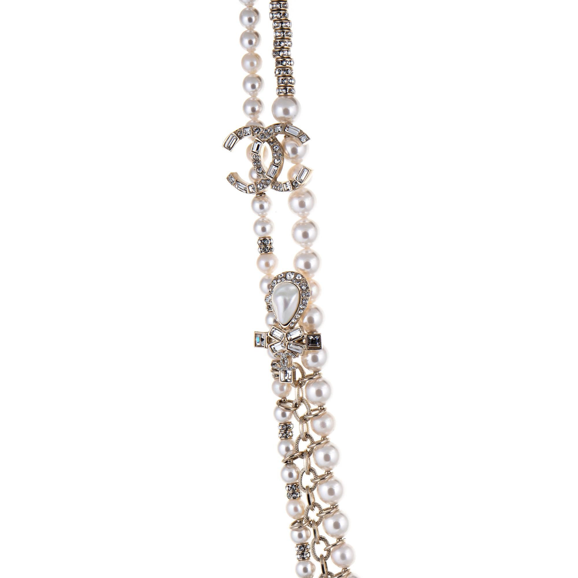 Pre-owned Chanel crystal graduated faux pearl necklace (or belt) crafted in light yellow gold-tone (circa 2019). 

The necklace features graduated 6mm to 8mm faux white pearls, separated with crystal-embellished stations. Two CC logos and four cross