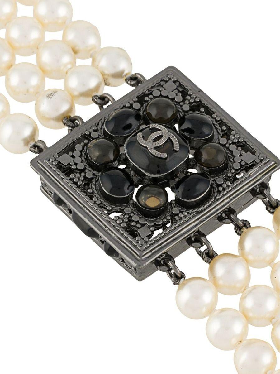 Crafted in France from gunmetal silver-tone metal, this iconic vintage pearl necklace from the Chanel 2015 collection features four individual strands of lustrous, threaded pearls, glass stone embellishments throughout and a spring-ring fastening.