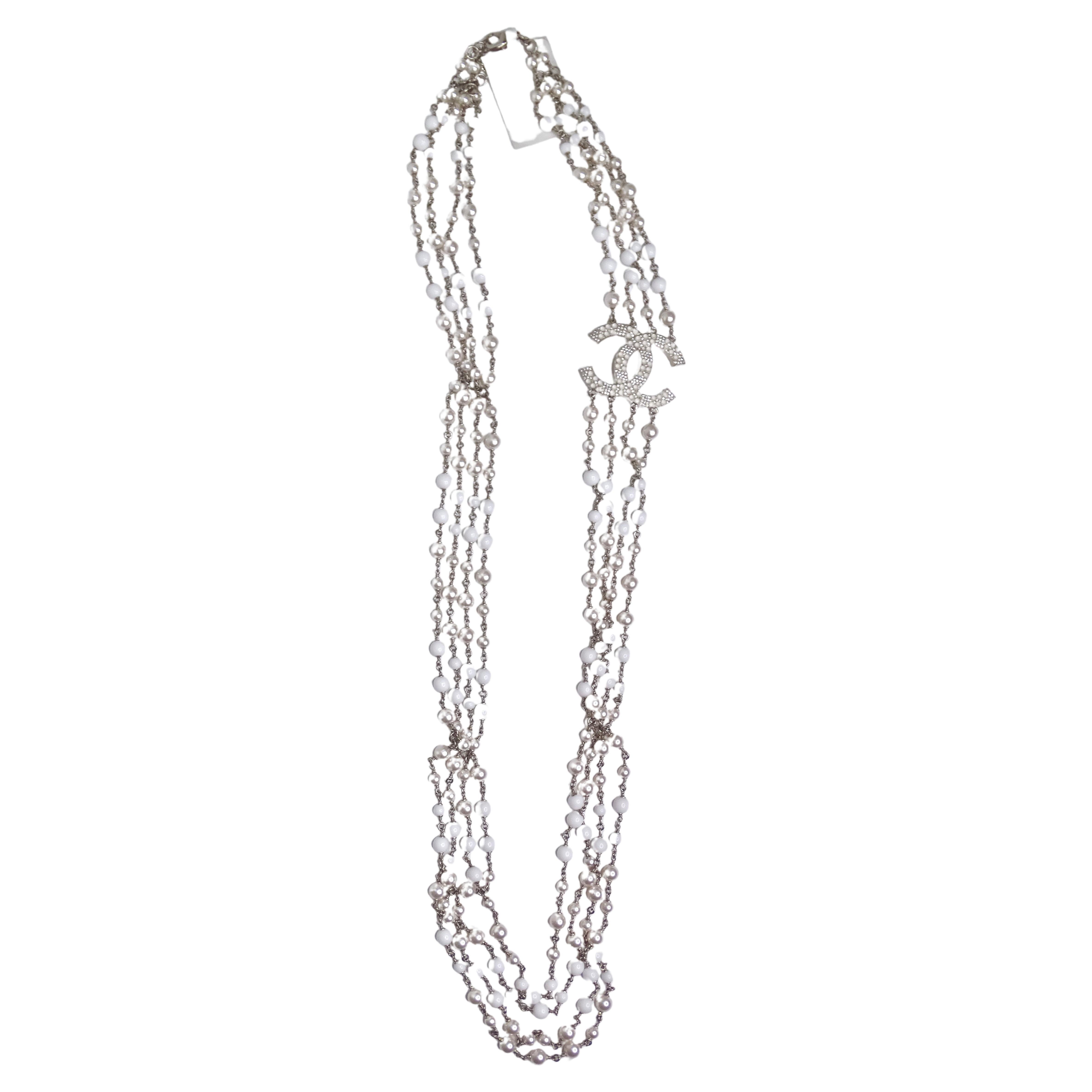 Introducing your new evening wear necklace! This is an iconic Chanel piece you need in your collection. It features silver hardware, white and silver beads, four very long strands, and a large 'CC' pendant measuring 2in x 1.5in. Pair this with your
