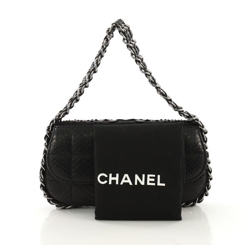 This Chanel Multichain Chocolate Bar Flap Bag Quilted Python Mini, crafted from genuine black quilted python, features multiple woven-in leather chain link straps and gunmetal-tone hardware. Its CC turn-lock closure opens to a black fabric interior
