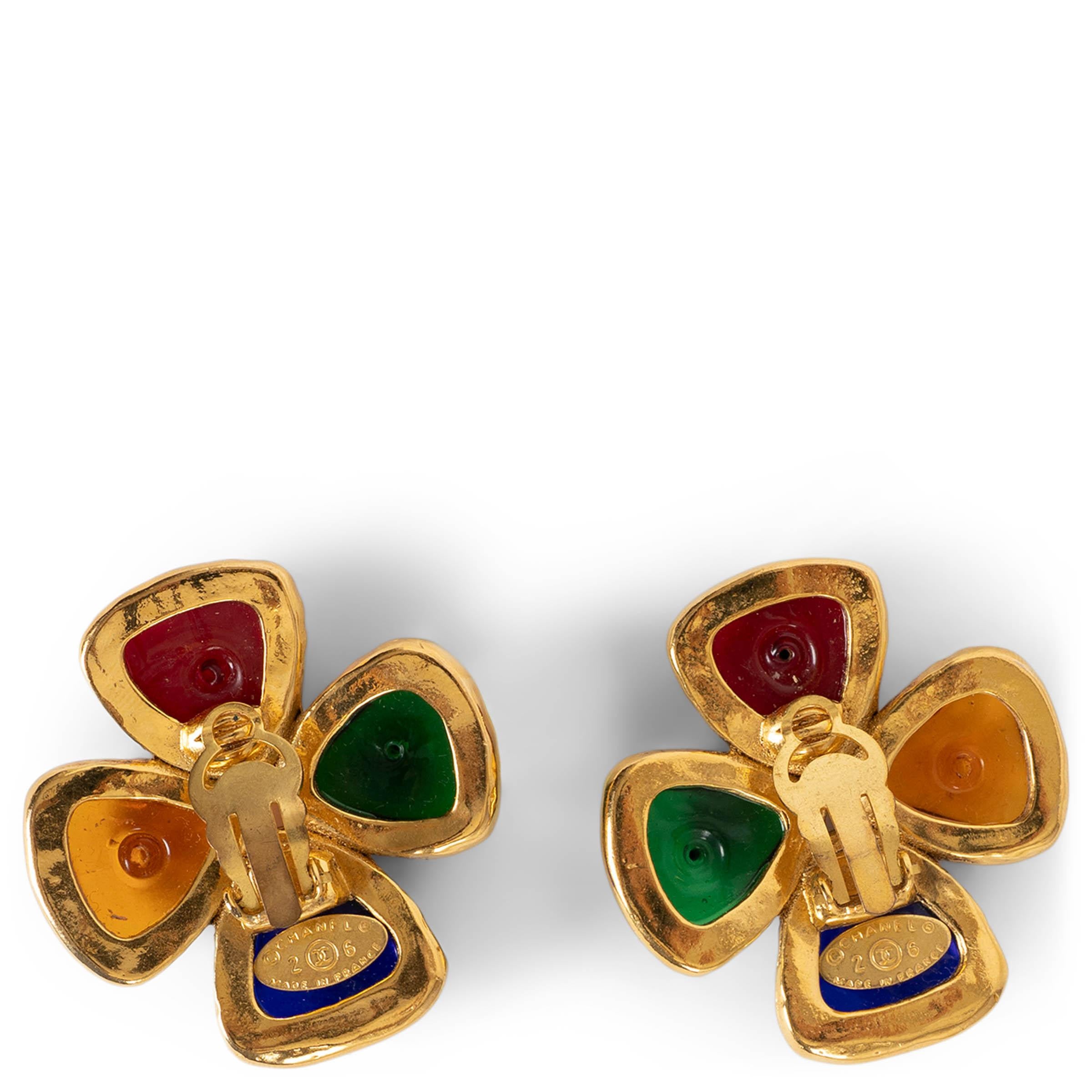 These 100% authentic Chanel clip-on earrings feature four vibrant, multicolored Gripoix glass cabochons—in jewel tones of blue, green, amber, and ruby—each handset in gold-plated metal to form an elegant clover motif. A striking and collectible